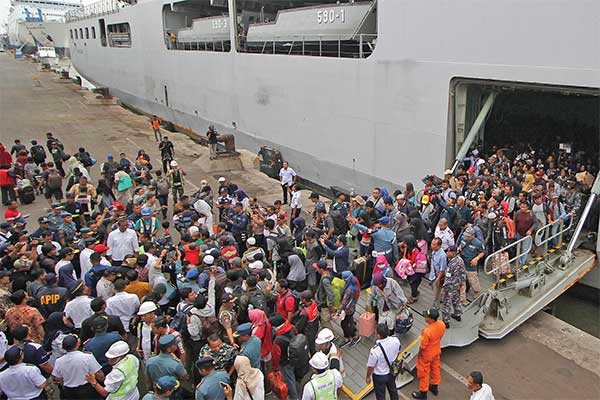 Penumpang KRI Makassar-590 turun membawa barang-barang mereka saat tiba di Pelabuhan Tanjung Perak, Surabaya, Jawa Timur, kemarin.