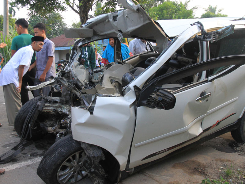 mobil minibus dengan Nopol BK 1085 ZS yang ringsek setelah bertabrakan dengan mobil bus BL 7776 AA di Jalan Lintas Nasional Medan-Banda Aceh