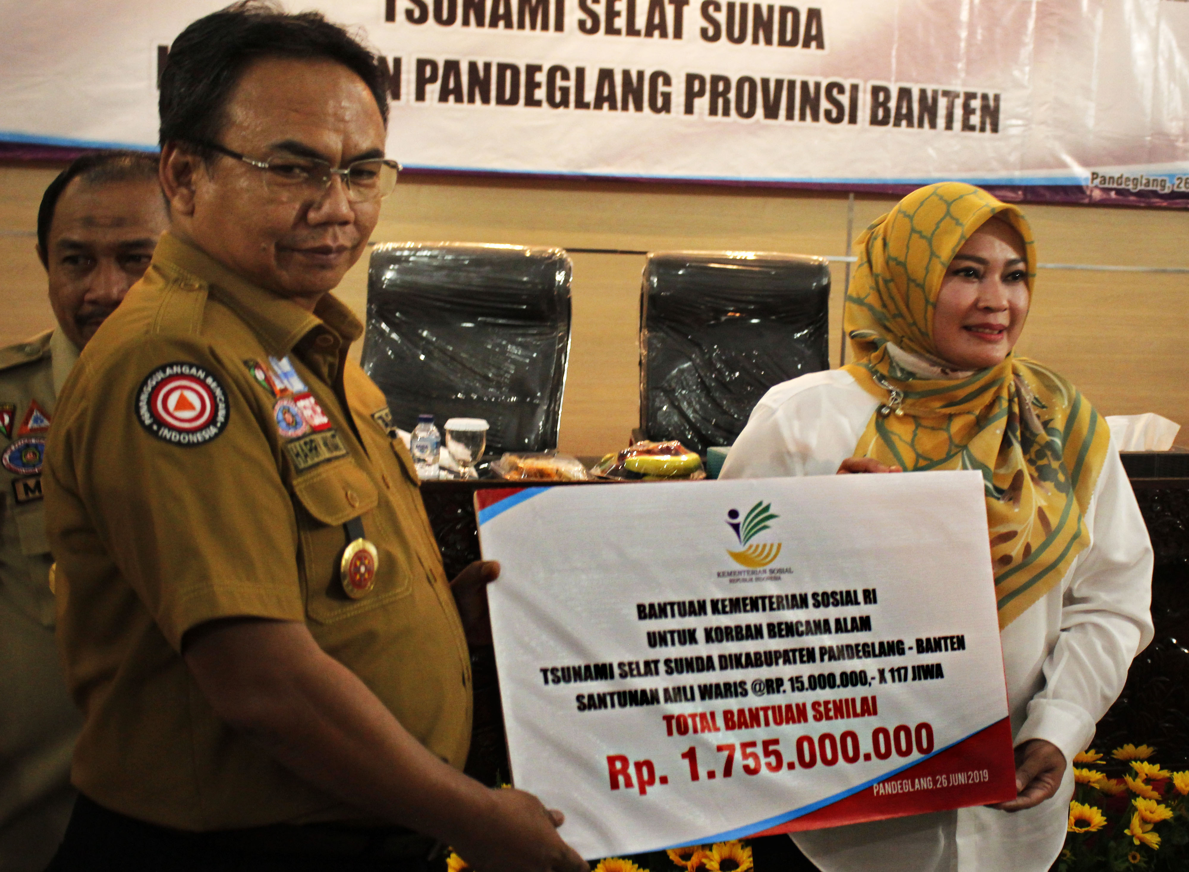 Perwakilan Kemensos Harry Hikmat (kiri) menyerahkan bantuan untuk korban Tsunami Selat Sunda kepada Bupati Pandeglang Irna Narulita