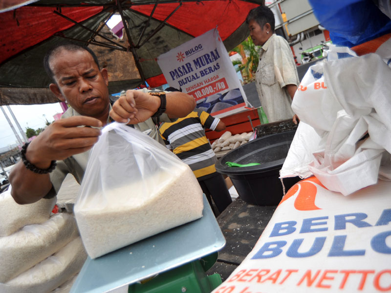 Petugas Bulog mengemas beras saat digelarnya pasar murah di Pasar Raya Padang, Sumatera Barat.