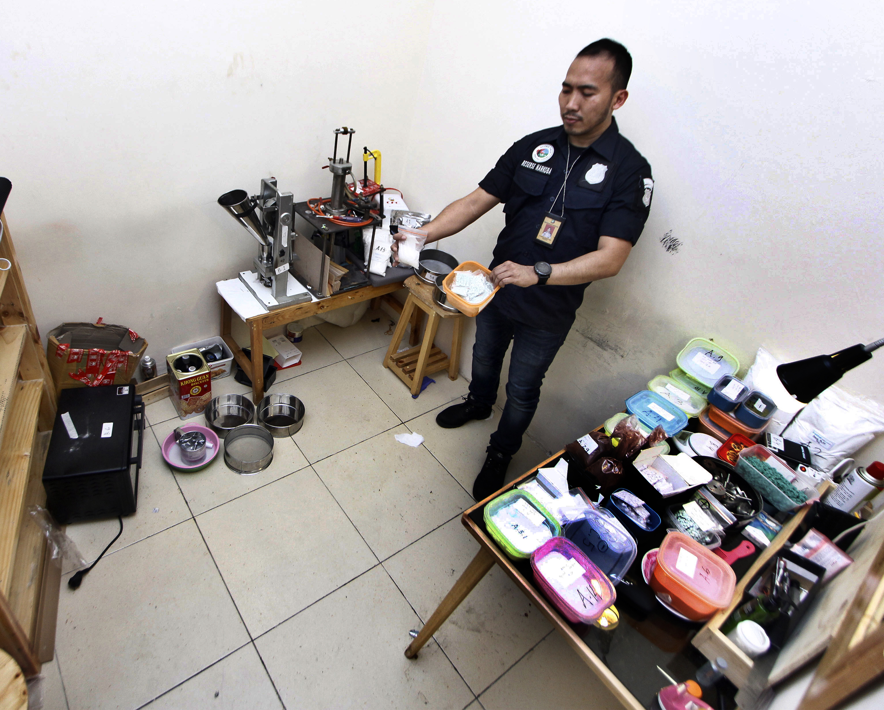  Personil Satuan Narkoba Polres Metro Jakarat Barat menunjukkan barang bukti di rumah produksi ekstasi di Perumahan Sentra Pondok Rajeg
