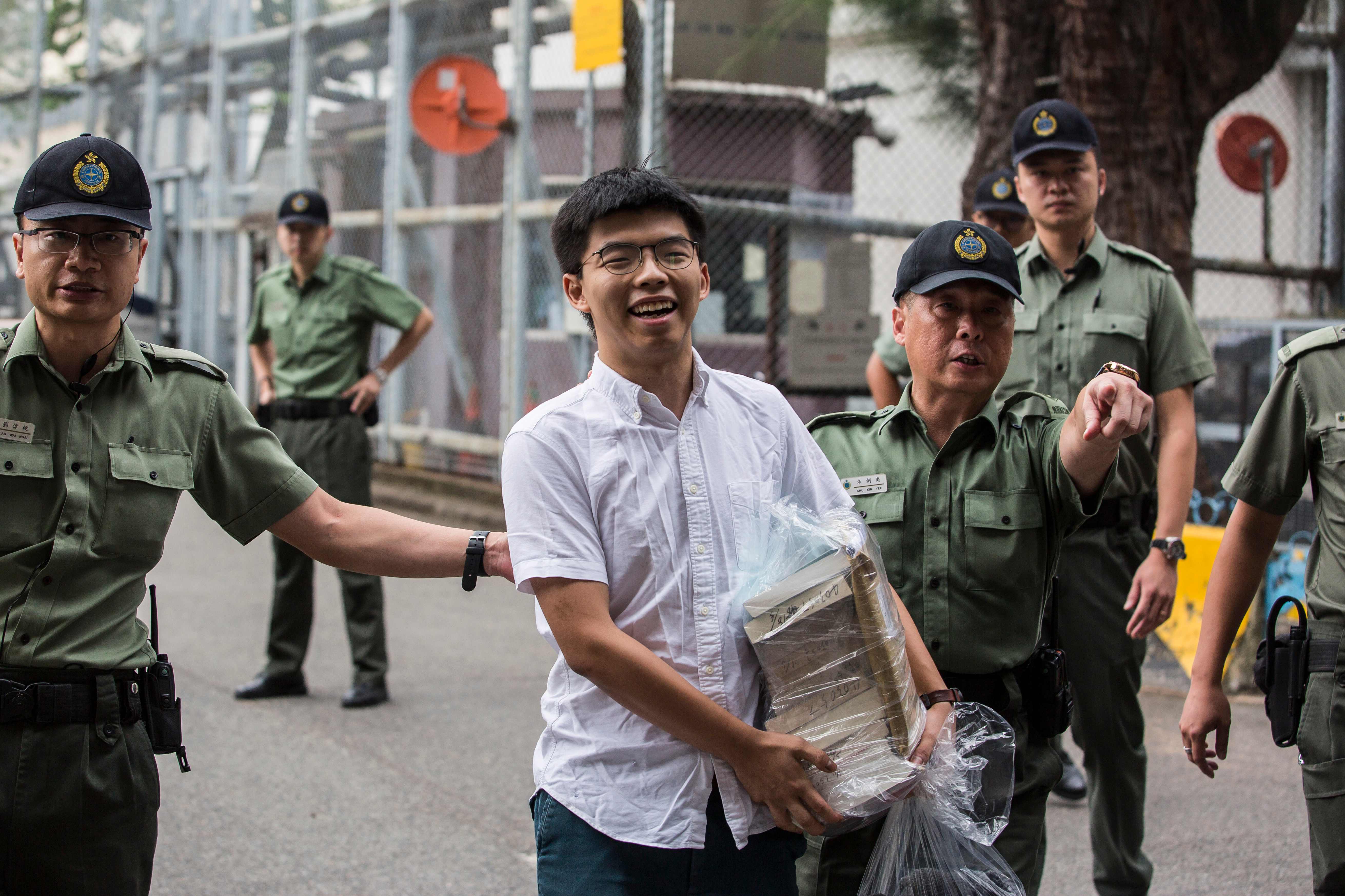 Aktivis demokrasi Hong Kong Joshua Wong (tengah) meninggalkan Lembaga Pemasyarakatan Lai Chi Kok di Hong Kong pada 17 Juni 2019.