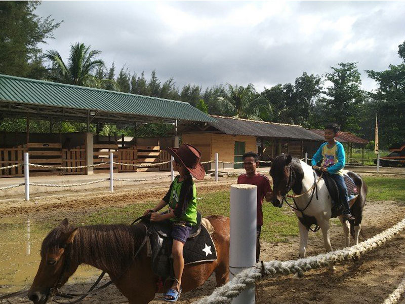 Dua anak sedang menunggangi kuda dalam menikmati liburan Idul Fitri 1440 Hijriah di Pangkalpinang, Bangka Belitung. 