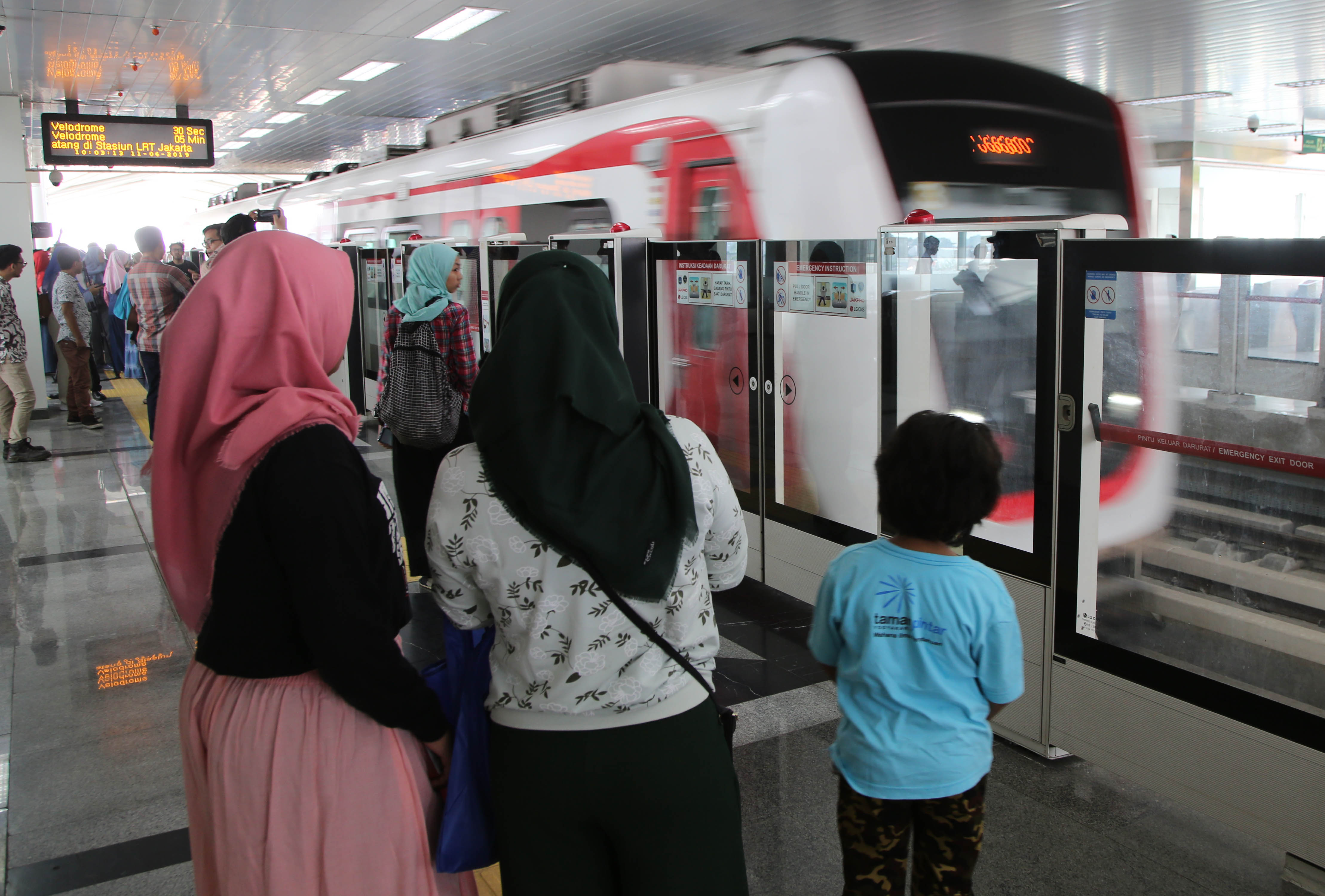 Warga menaiki LRT dari Stasiun Boulevard Utara menuju Velodrome, Jakarta.