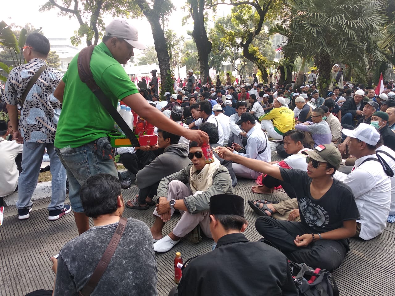 Peserta aksi membeli makan dan minuman dari pedagang sekitar