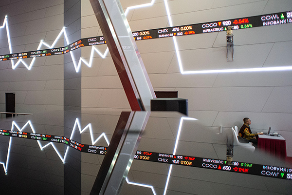 Karyawan beraktivitas di dekat grafik pergerakan saham di gedung Bursa Efek Indonesia