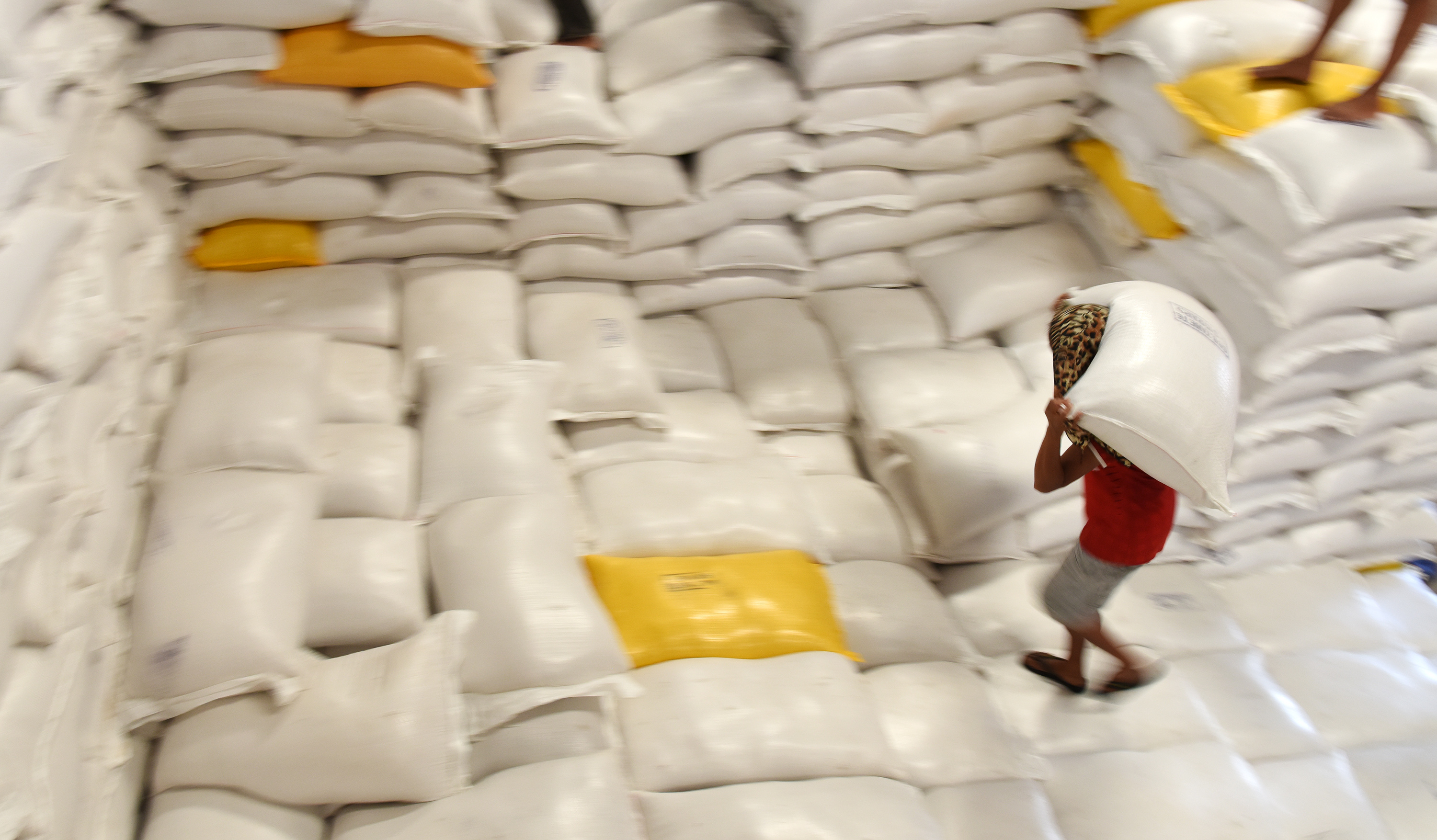 Pekerja mengangkat beras di Gudang Bulog Makassar, Sulawesi Selatan.