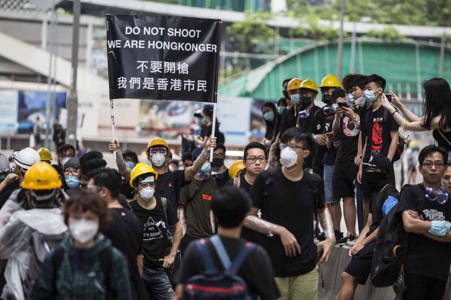 Seorang pengunjuk rasa membentangkan poster saat jutaan demonstran turun ke jalan di pusat Kota Hong Kong, kemarin.