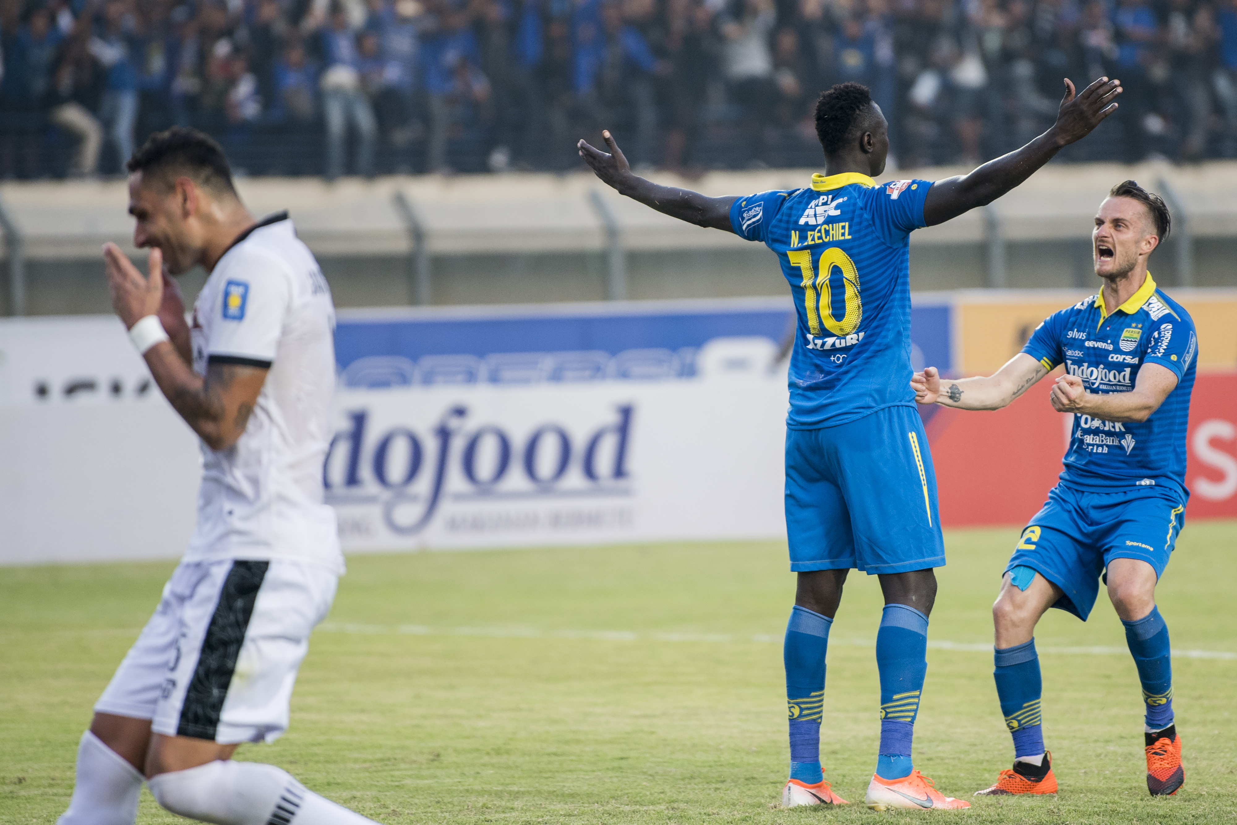 Pesepak bola Persib Bandung Rene Mihelic (kanan) dan Ezechiel Ndouasel (kedua kanan) merayakan kemenangan 
