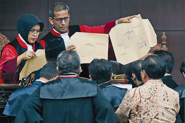 Hakim konstitusi Saldi Isra (kanan) dan Enny Nurbaningsih mengecek alat bukti sampul surat suara