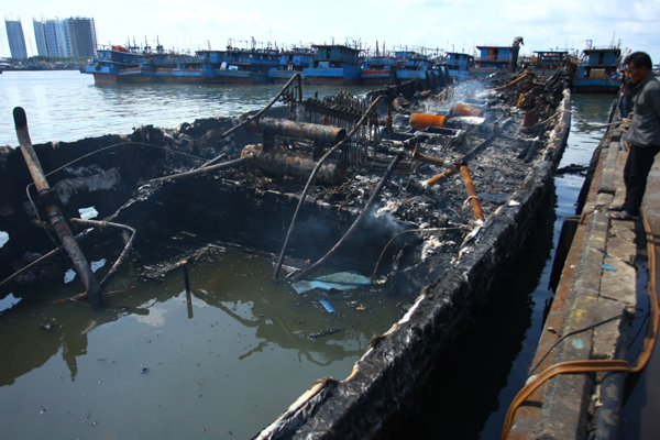 Ilustrasi: Warga melihat bangkai kapal yang hangus terbakar di Pelabuhan Muara Baru, Jakarta, Minggu (24/2).