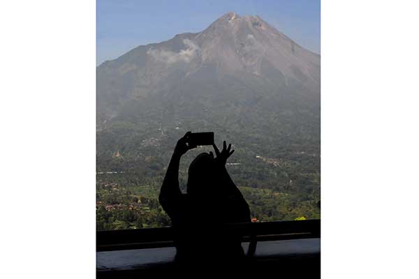 Warga melihat pemandangan Gunung Merapi di kawasan Magelang, Jawa Tengah