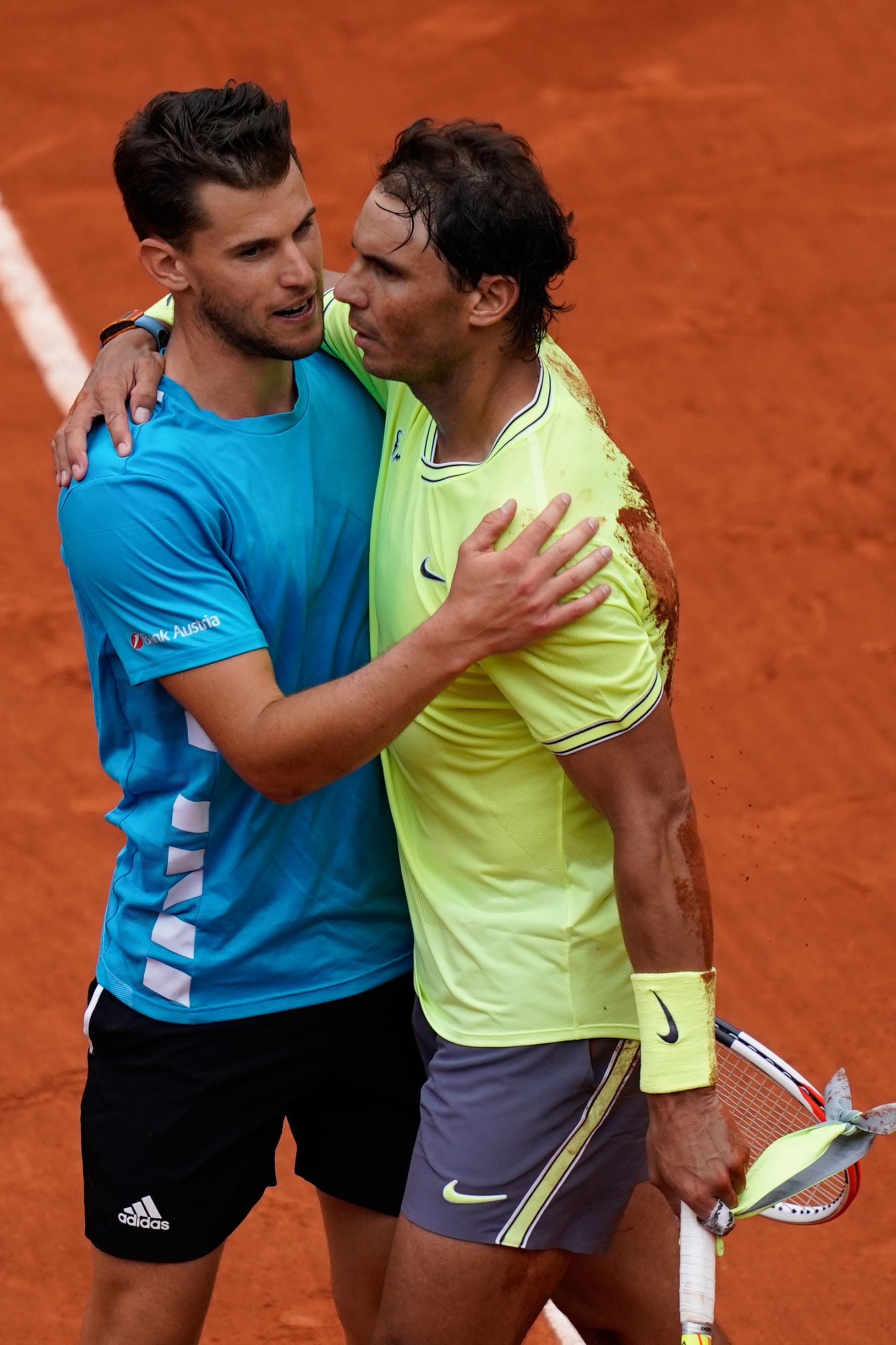 Petenis asal Spanyol Rafael Nadal (baju kuning) merangkul Petenis asal Austria Dominic Thiem (baju biru)