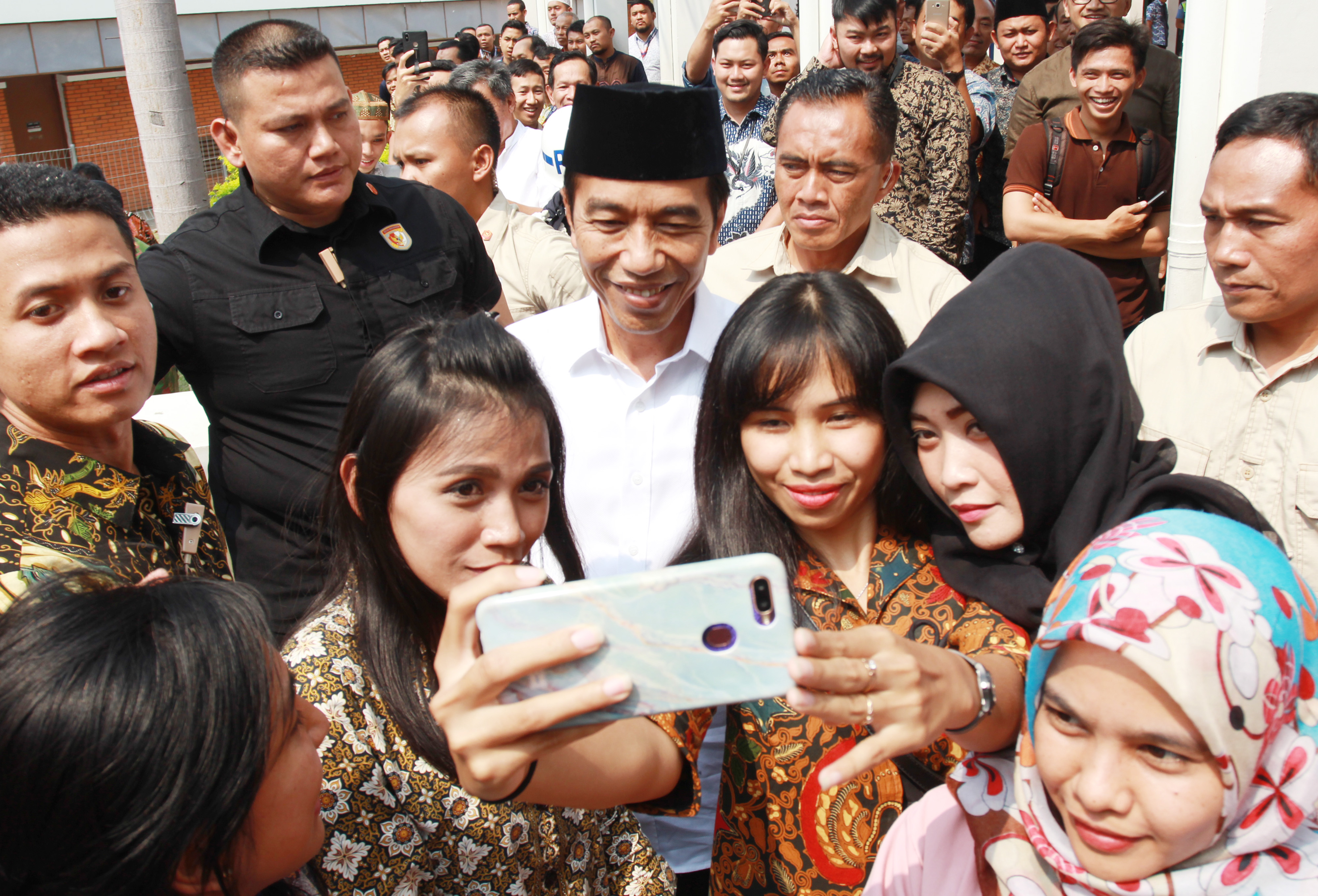 Presiden Joko Widodo melayani jamaah masjid Nurul Barkah berswafoto usai melaksanakan Salat Jumat.
