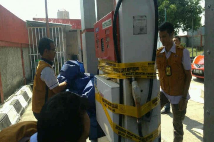 Petugas dari Direktorat Jenderal Perlindungan Konsumen dan Tertib Niaga Kementerian Perdagangan memasang segel pompa BBM di SPBU.