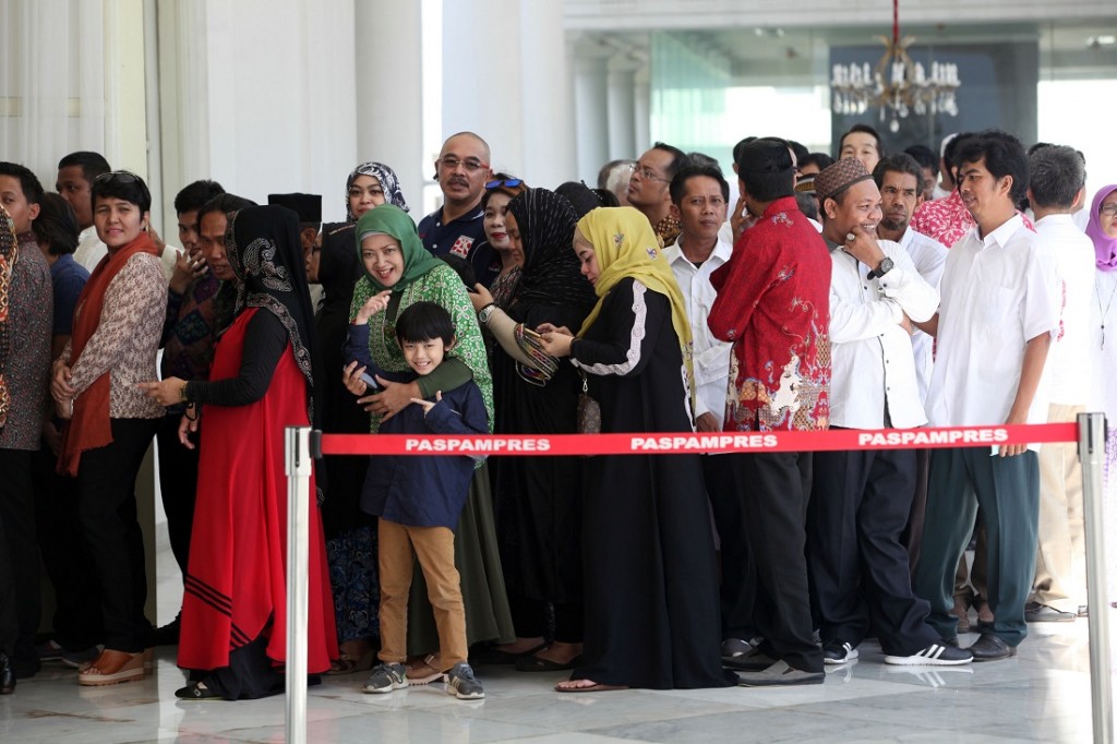 Masyarakat antri untuk bersalaman dengan Presiden Joko Widodo (kiri) dan Ibu Negara Iriana Joko Widodo serta Wakil Presiden Jusuf Kalla.
