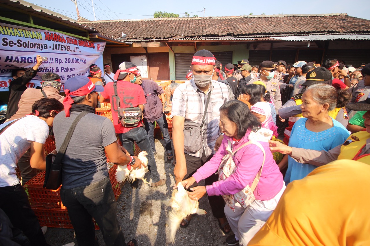 Peternak anggota Pinsar Solo Raya menggelar protes dengan cara membagi bagikan ayam secara gratis kepada masyarakat di Pasar Pinsar Solo