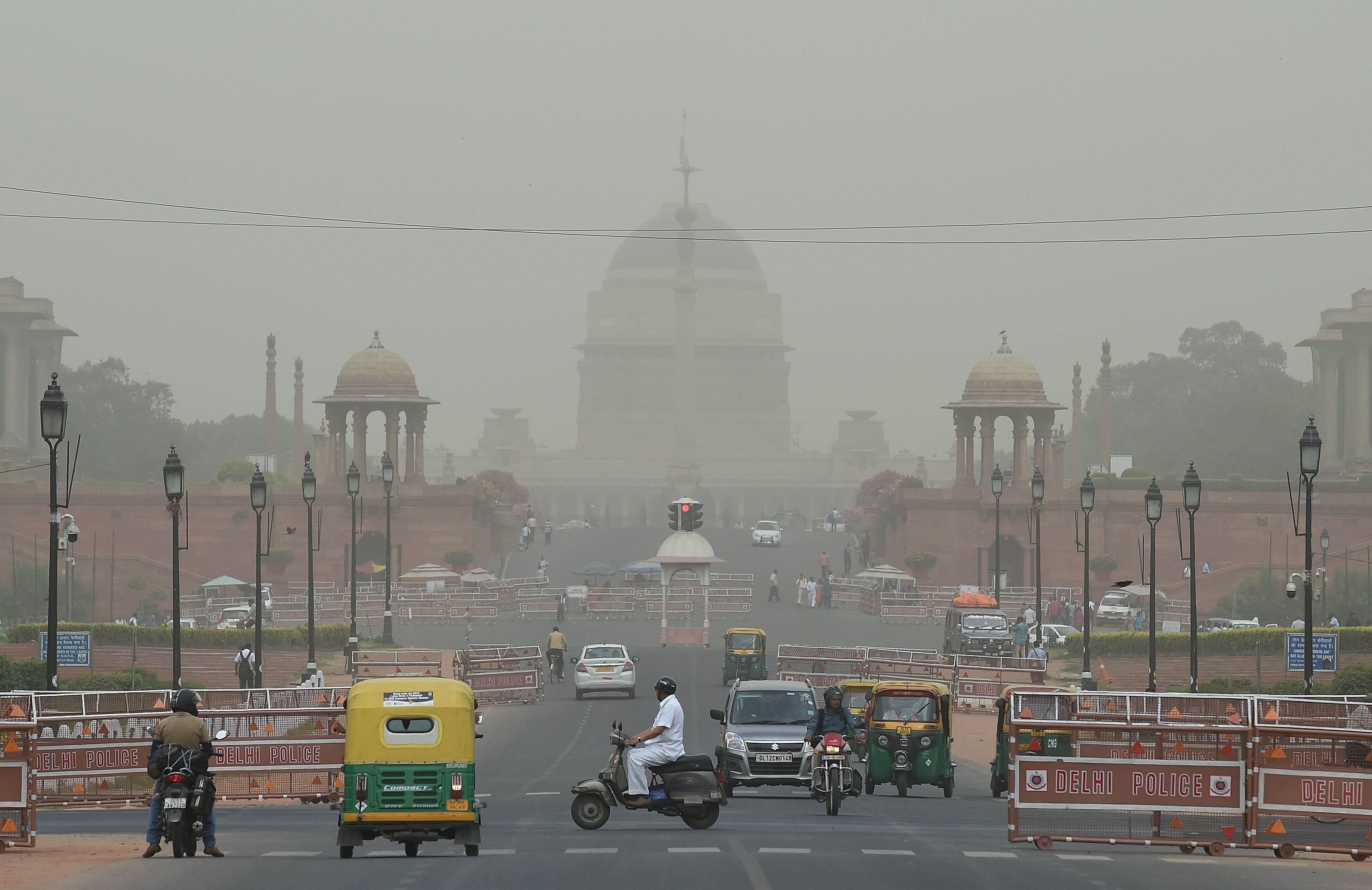 Kendaraan melewati di gedung presiiden India saat cuaca panas dan suhu udara yang relatif tinggi