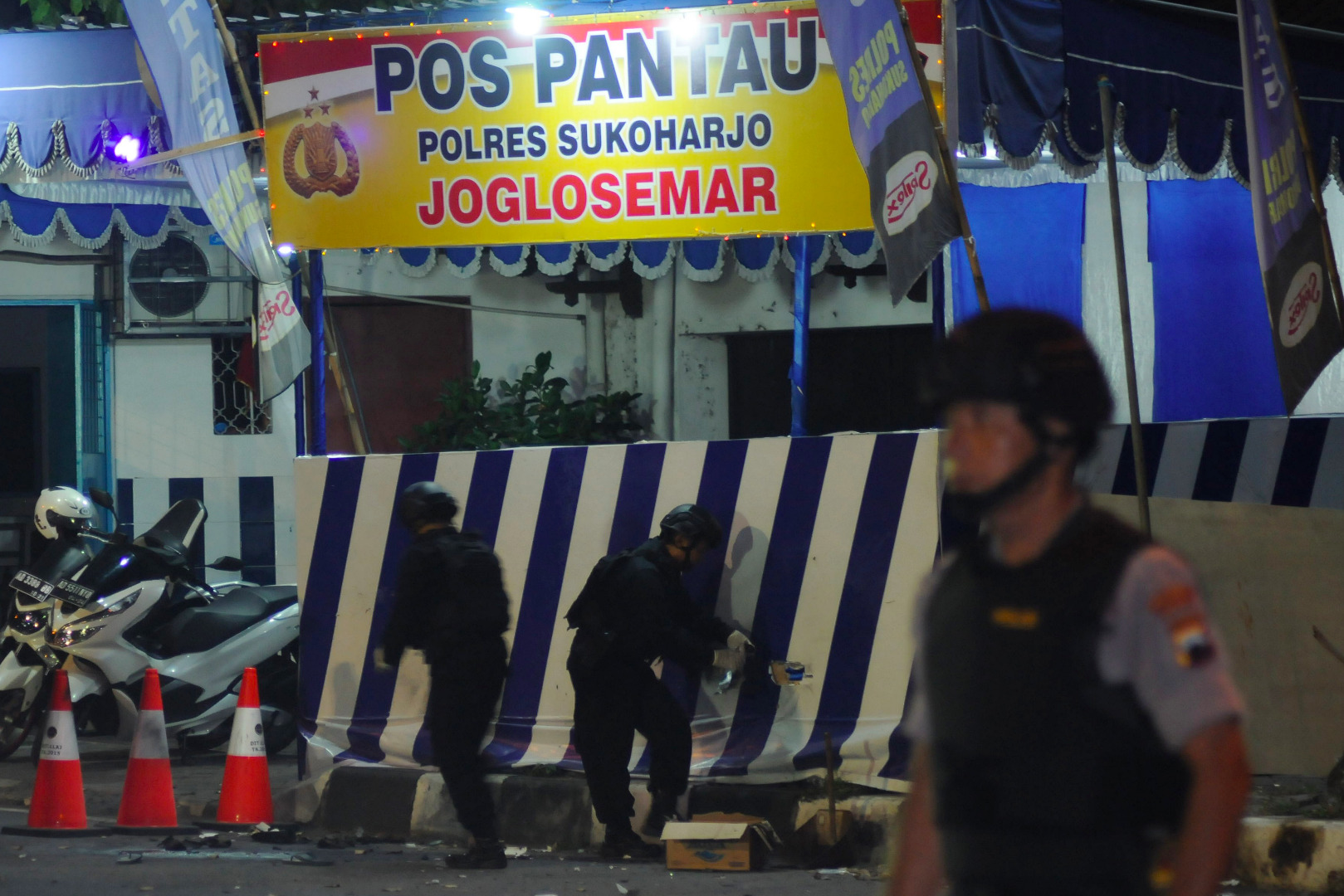 Petugas Polisi melakukan olah tempat kejadian perkara lokasi kejadian bom bunuh diri di Pospam Kartasura, Sukoharjo, Jawa Tengah