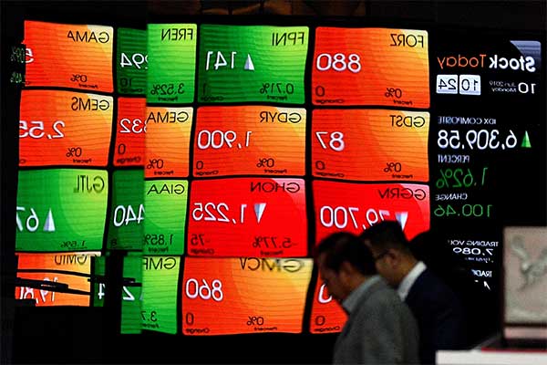 Karyawan melintas di depan layar pergerakan Indeks Harga Saham Gabungan (IHSG), Bursa Efek Indonesia, Jakarta, Senin (10/6/2019).