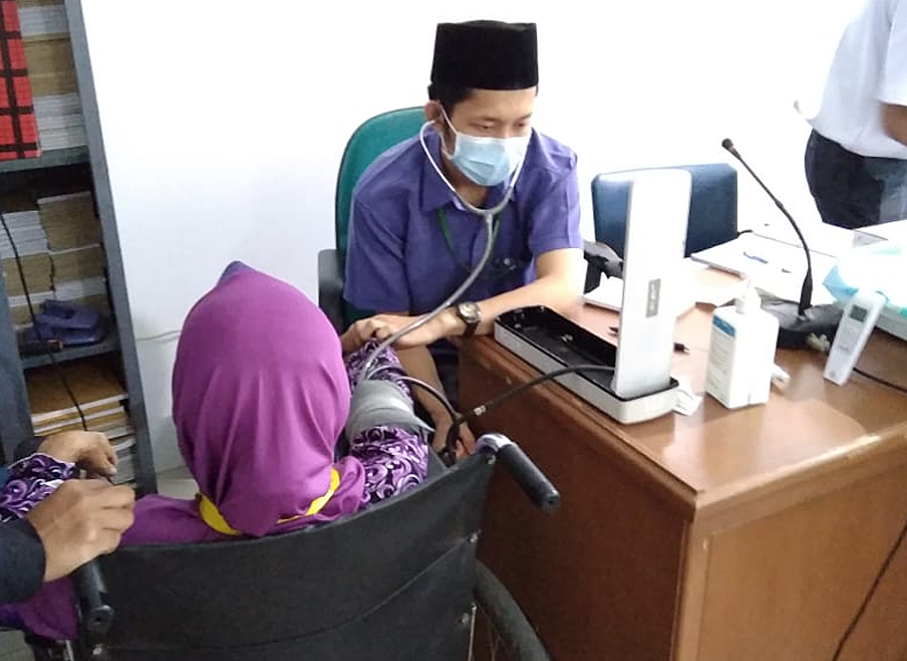 Petugas kesehatan memeriksa seorang pasien di Puskesmas Kecamatan Kalideres, Jakarta Barat.