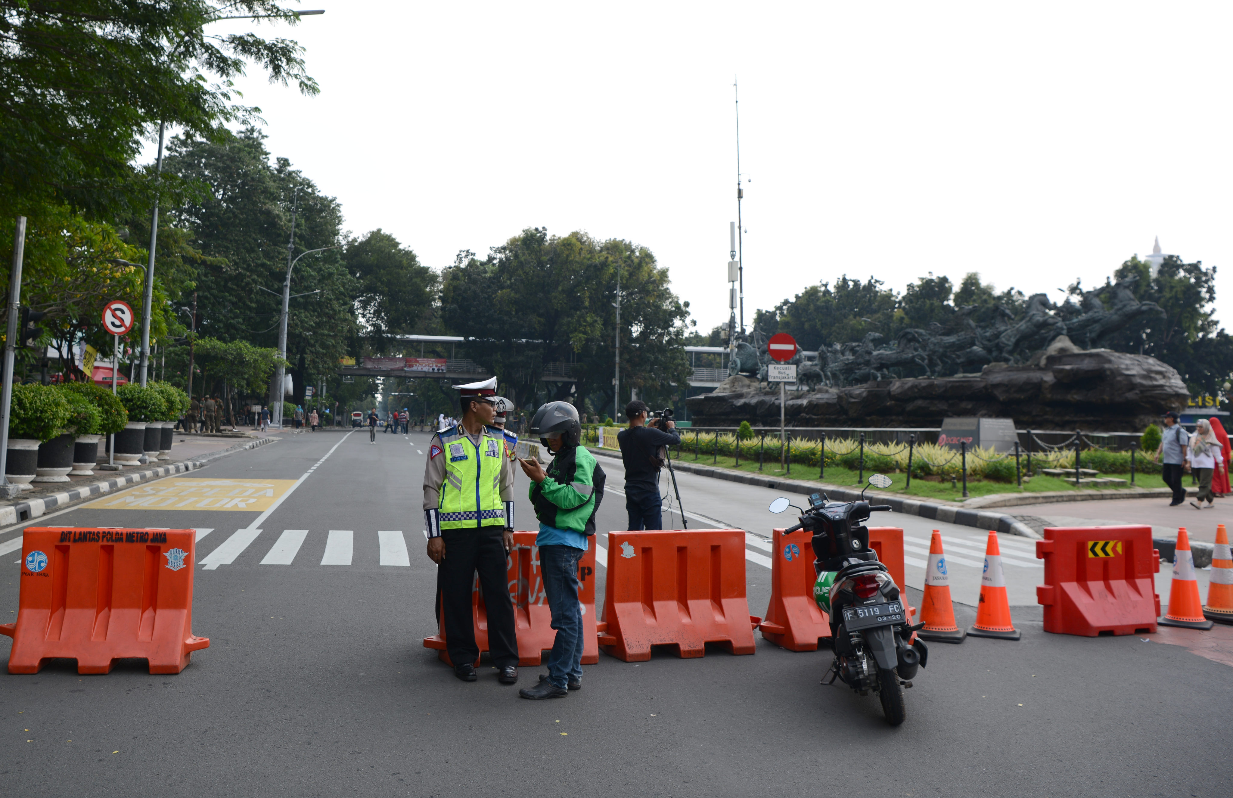 Polisi lalu lintas berjaga di ujung Jalan Medan Merdeka Barat yang ditutup di Jakarta, Jumat (14/6)