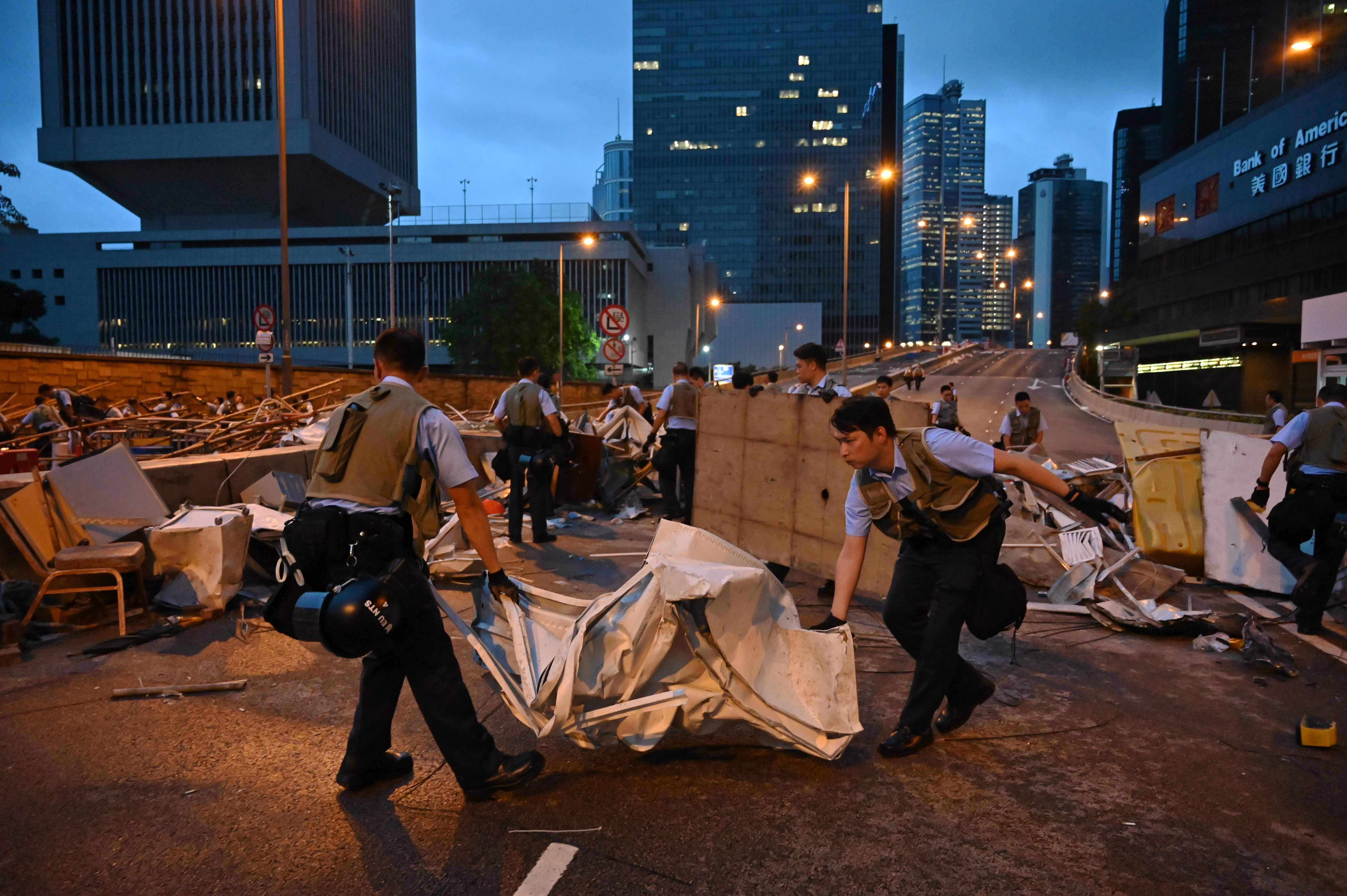 Polisi Hong Kong membongkar blokade yang dipasang demonstran pada Kamis (13/6).