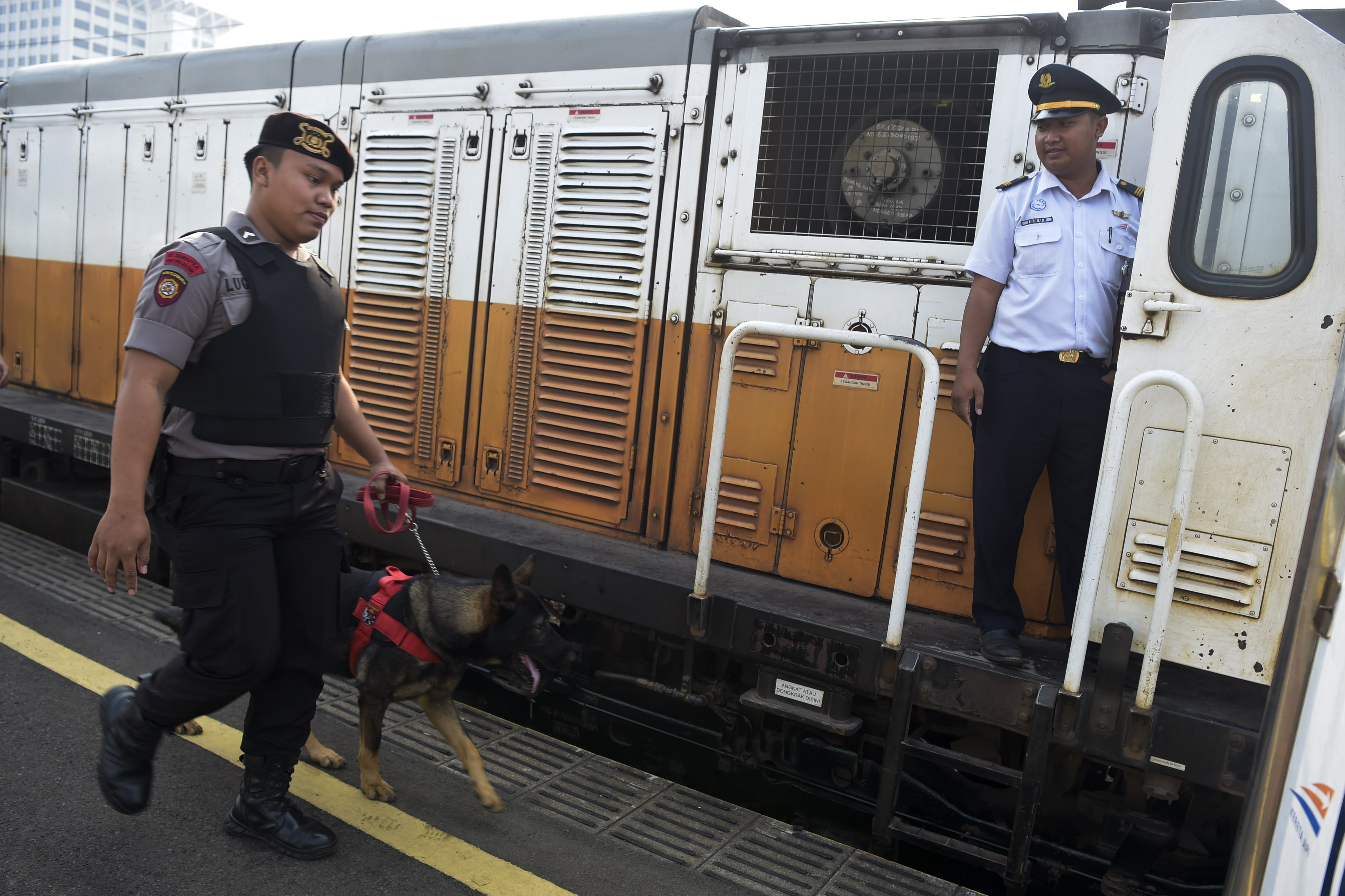 Petugas unit K9 Polda Metro Jaya (unit keamanan dengan bantuan anjing pelacak melakukan pengamanan di Stasiun Gambir, Jakarta.