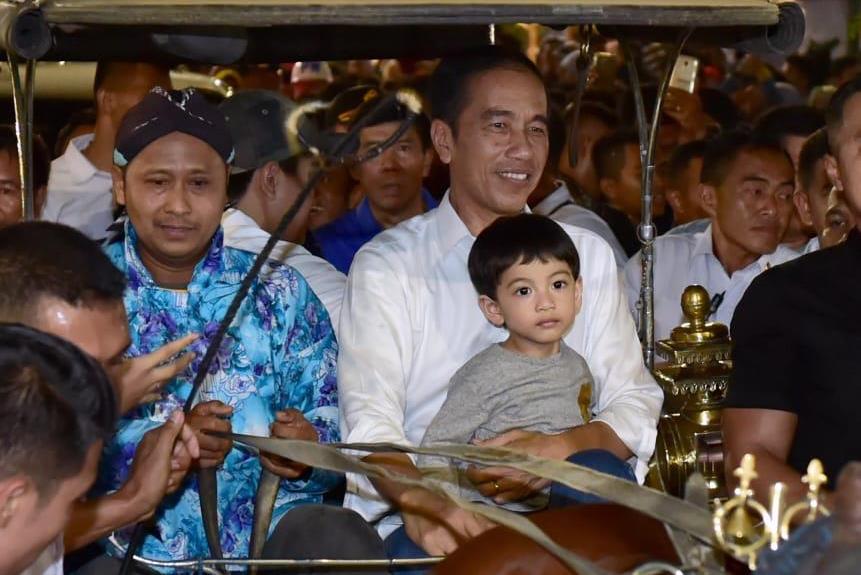 Presiden Joko Widodo menggendong cucunya, Jan Ethes, saat naik andong, Rabu (6/6).
