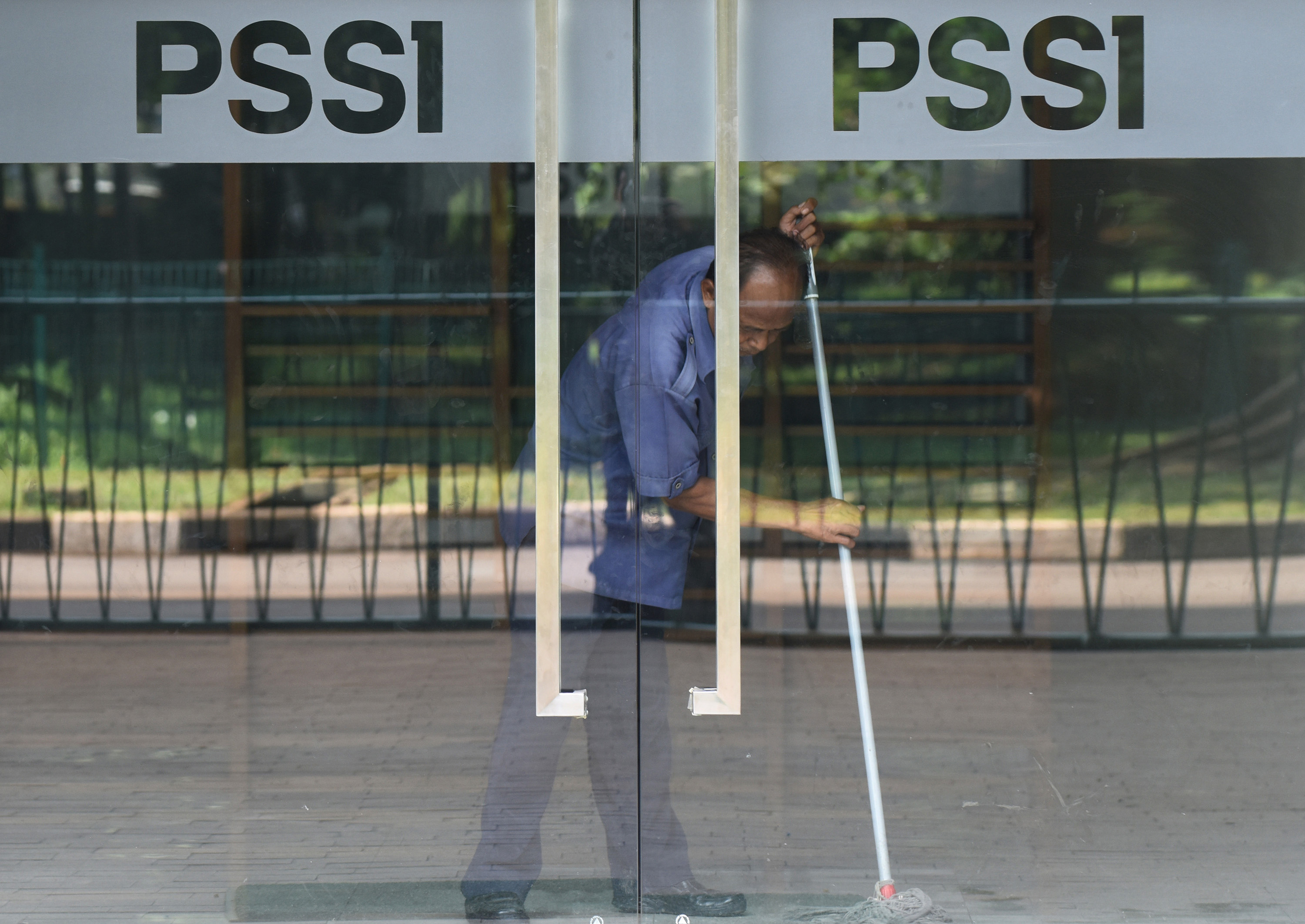 Seorang pekerja membersihkan kantor PSSI di Kompleks Stadion Utama Gelora Bung Karno, Jakarta. 