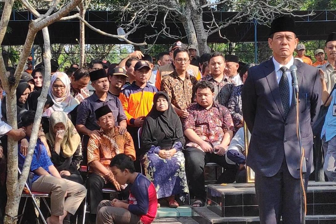 Kepala BNPB Doni Mondardo dengan latar belakang keluarga almarhum Sutopo Purwo NUgroho saat upacara pemakaman di Boyolali, Senin (8/7).