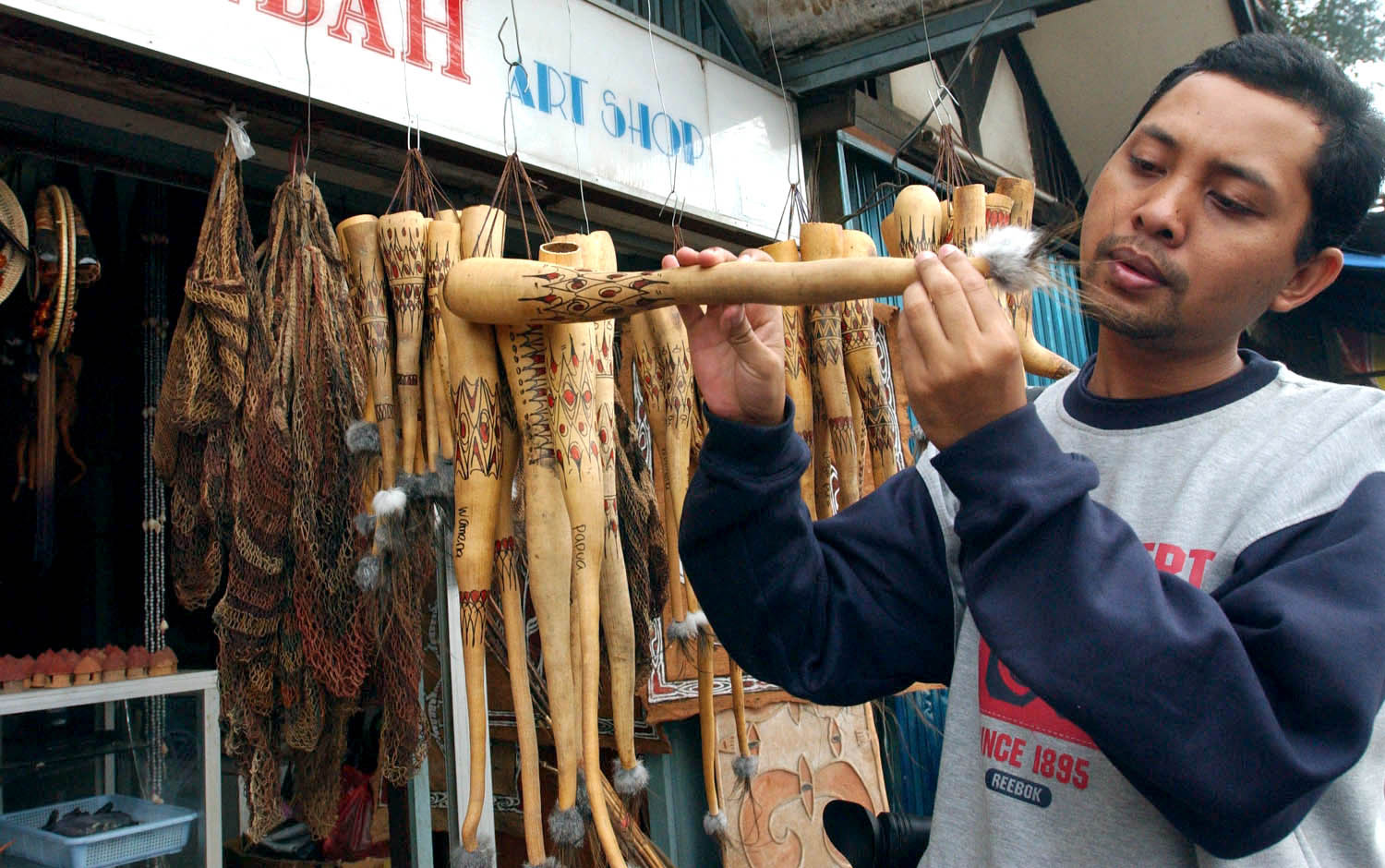 Seorang wisatawan lokal mengamati sebuah koteka yang dijual sebagai barang suvenir di sekitar pasar Hamadi, Jayapura, Papua.