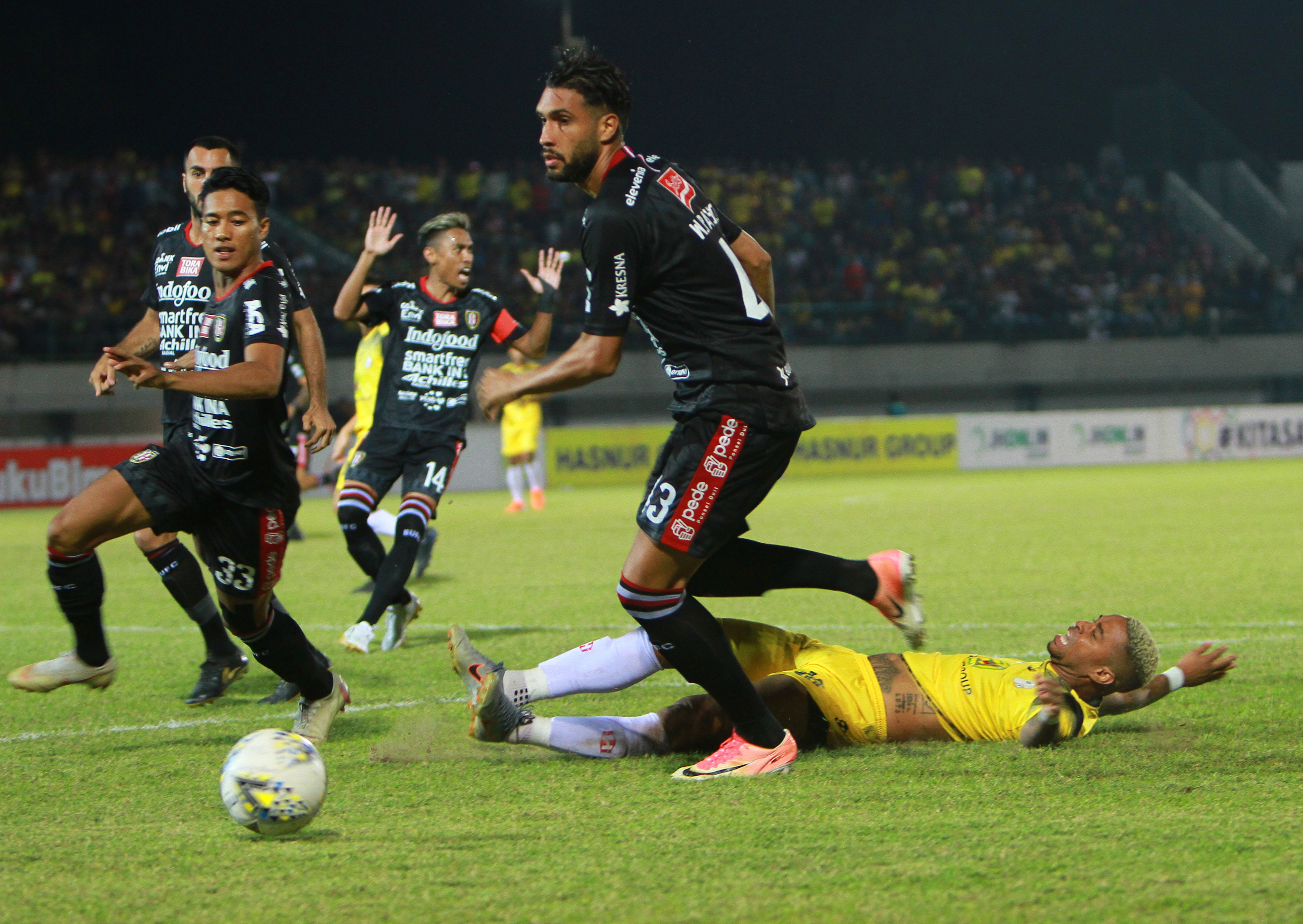  Pemain Barito Putera Rafael Feital Da Silva terjatuh saat mencoba melewati hadangan pesepak bola Bali United.