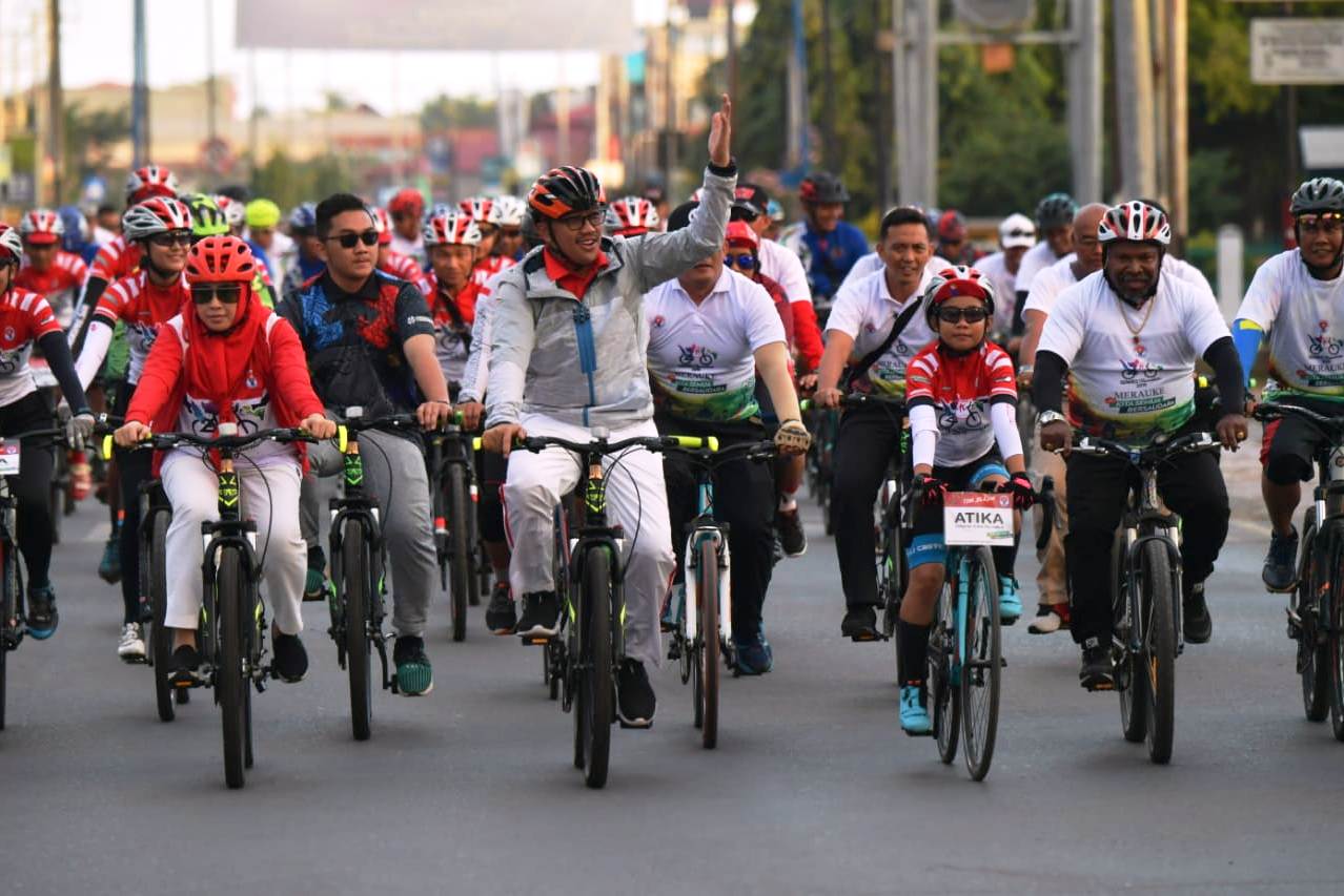 Menpora Imam Nahrawi (melambaikan tangan) bersepeda kelilingi Kota Merauke.