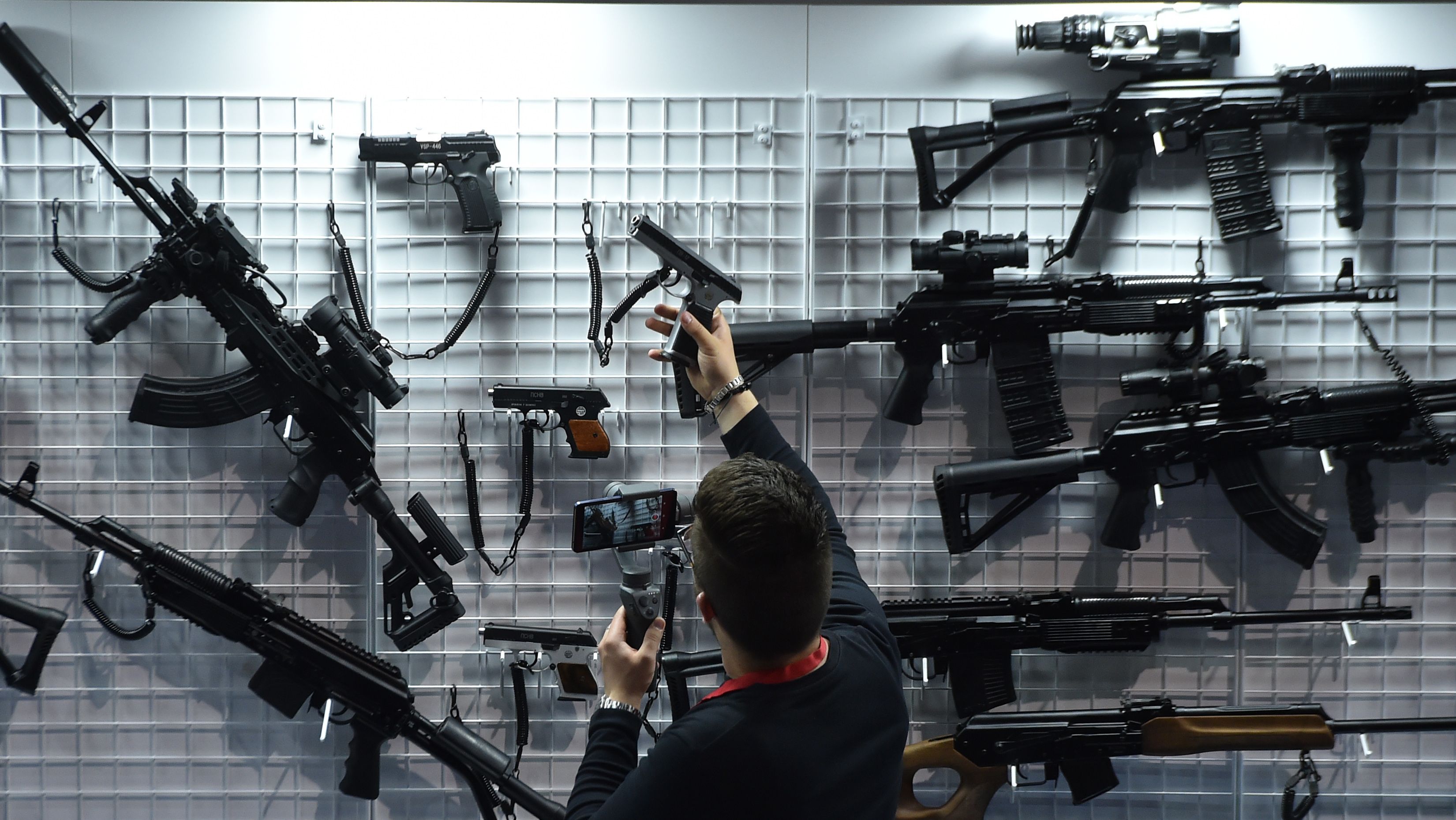 Seorang pria memeriksa pistol ketika mengunjungi Pameran senjata api