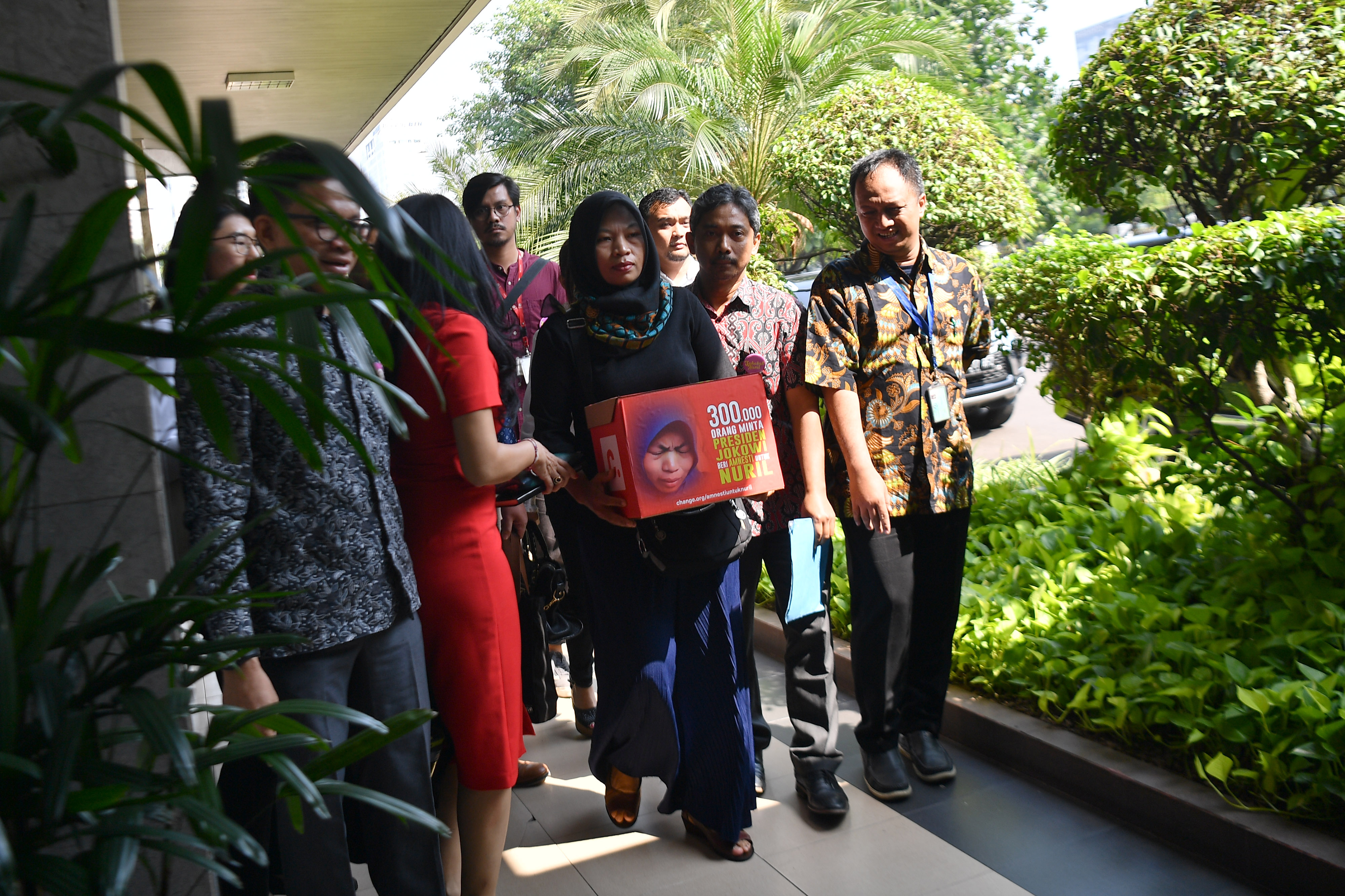 Terpidana kasus pelanggaran UU ITE Baiq Nuril Maknun (ketiga kanan) tiba di Kantor Staf Presiden, Jakarta, 15 Juli 2019.