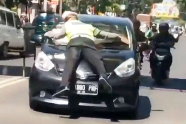 Polisi lalu lintas yang hendak menilangnya terseret oleh pengemudi yang akan ditilang