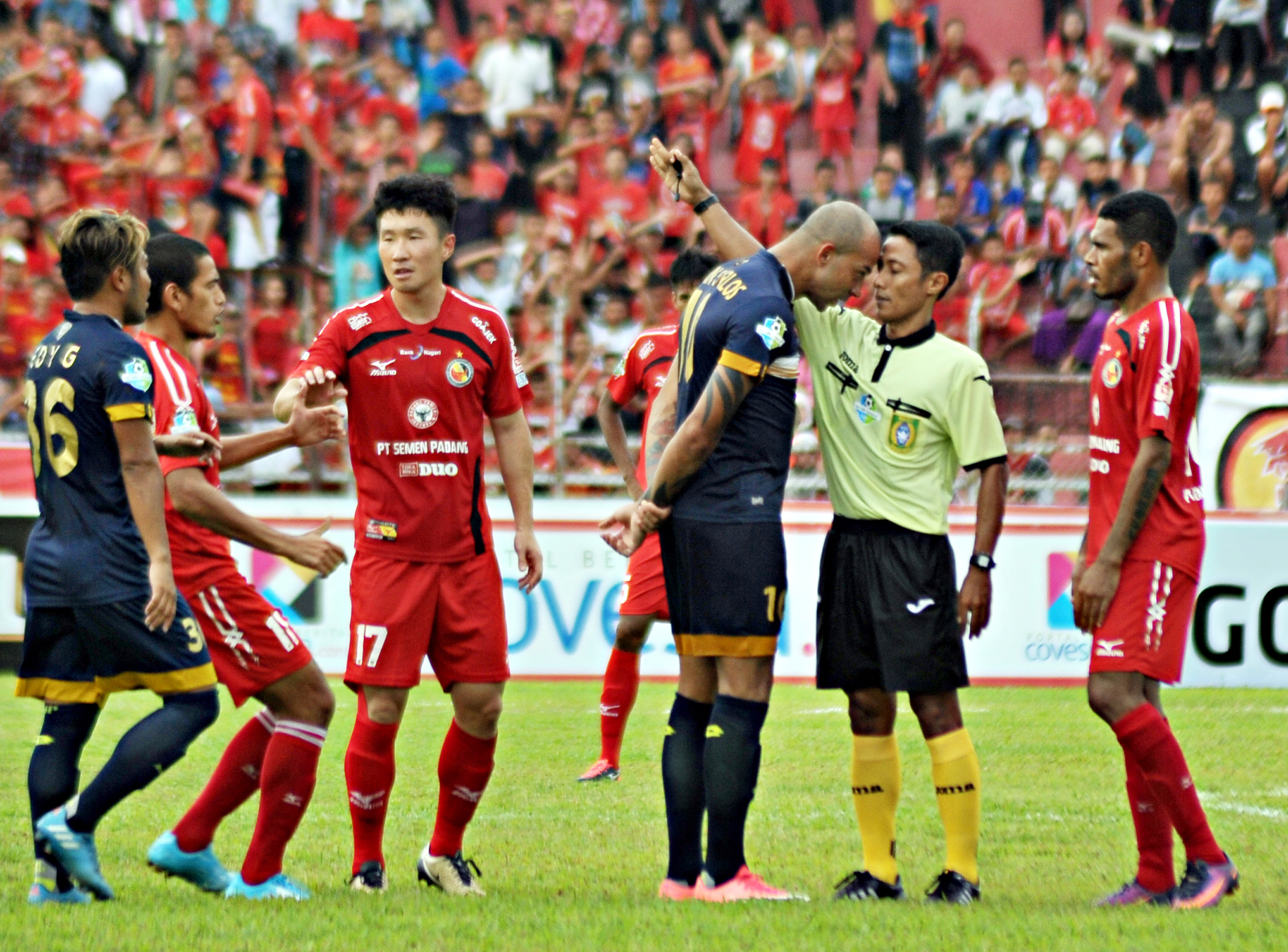 Pemain Persela Lamongan, Ivan Carlos (ketiga kiri) membenturkan kepalanya ke wasit, M Adung (kedua kanan), setelah diganjar kartu merah.