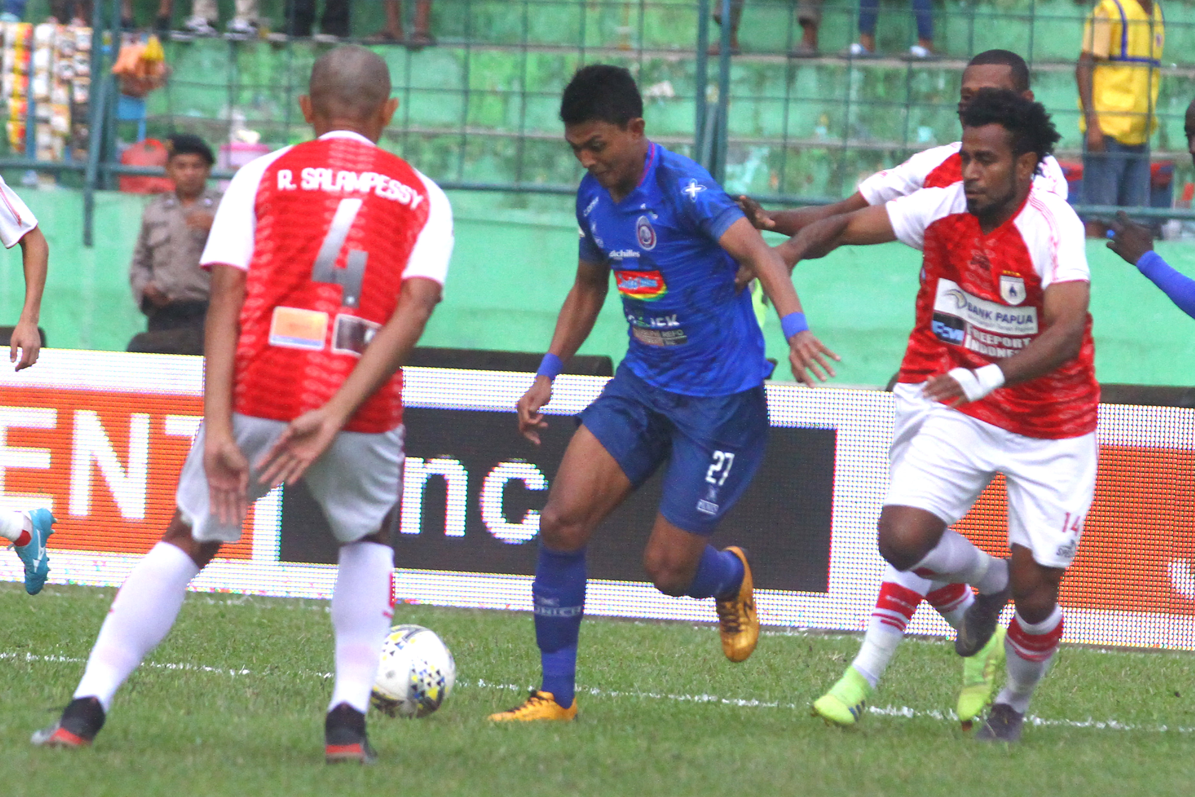 Pesepak bola Arema FC, Dedi Setiawan (dua dari kiri) berusaha melewati hadangan tiga pesepak bola Persipura Jayapura