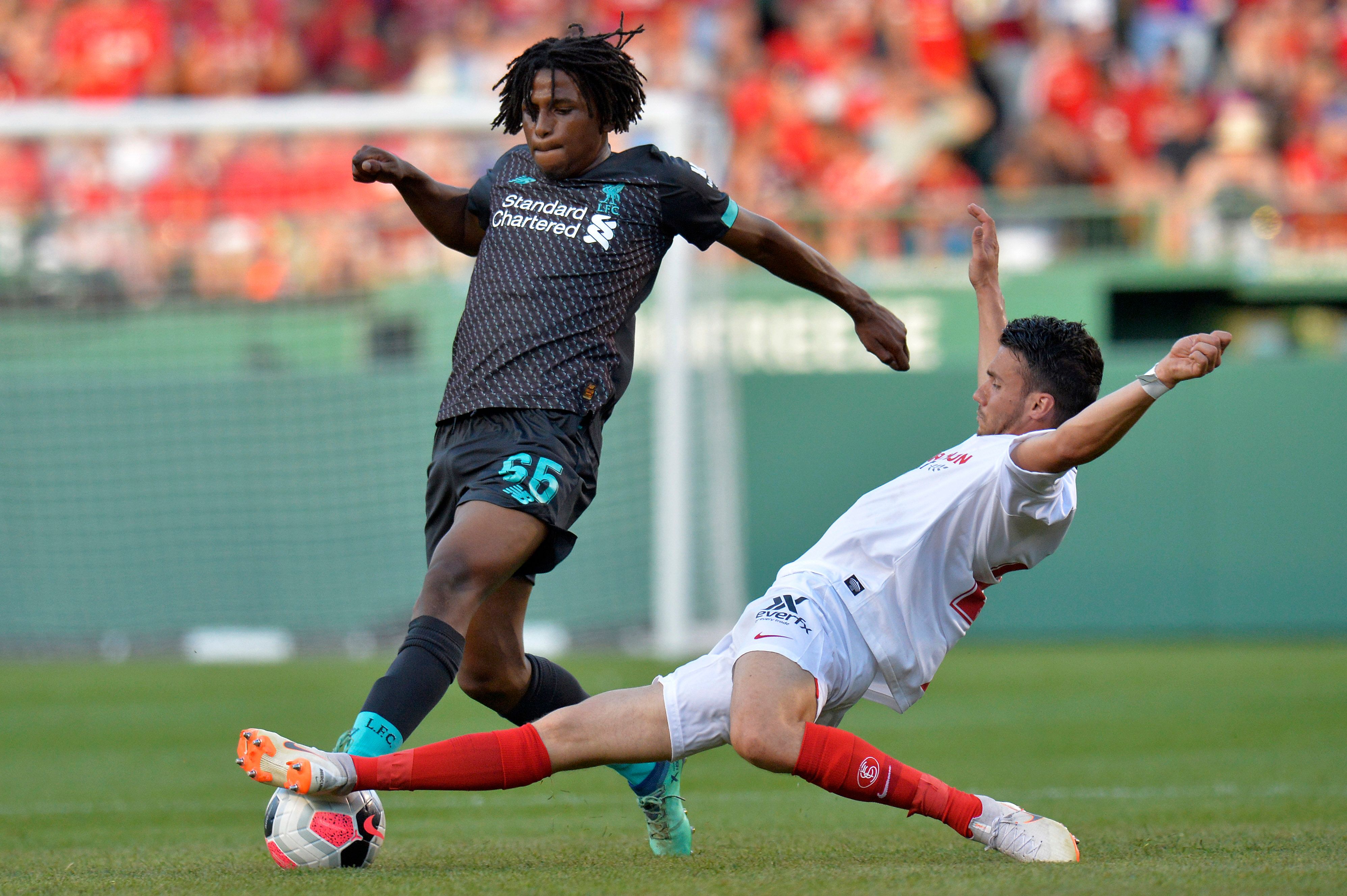 Pemain muda Liverpool Yasser Larouci (kiri) mencoba menghindari terjangan pemain Sevilla Sebastien Corchia pada laga pramusim di Boston, AS.