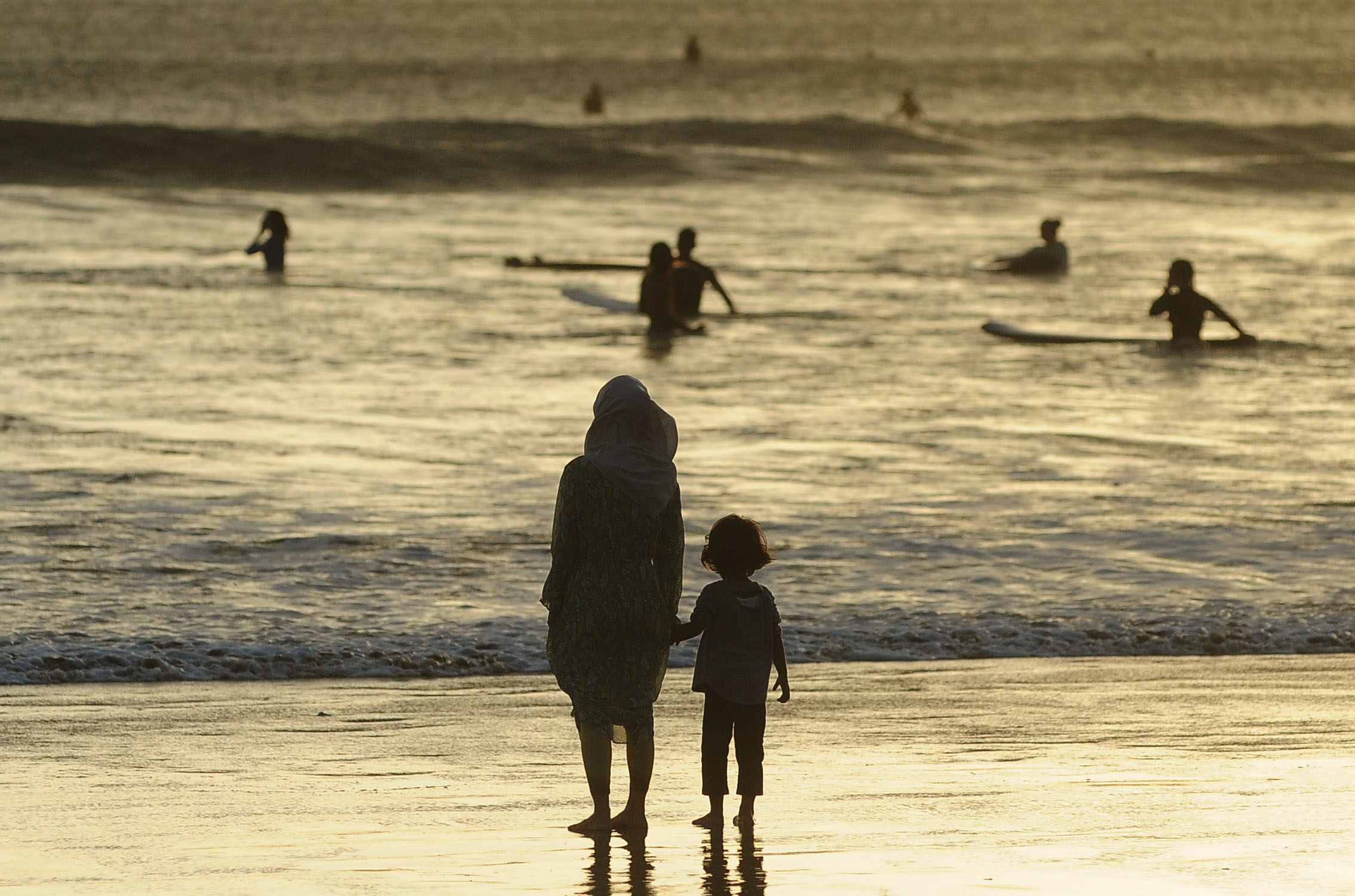 Wisatawan menikmati suasana objek wisata Pantai Kuta, Badung, Bali