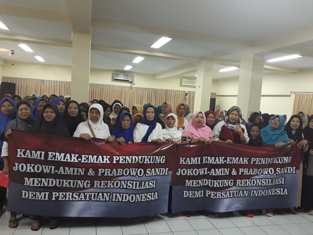 Para ibu membawa spaduk yang mendukung persatuan Indonesia.
