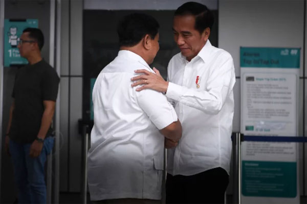 Presiden Joko Widodo (kanan) dan Ketua Umum Partai Gerindra Prabowo Subianto (kedua kanan) berpelukan saat tiba di Stasiun MRT Lebak Bulus, 