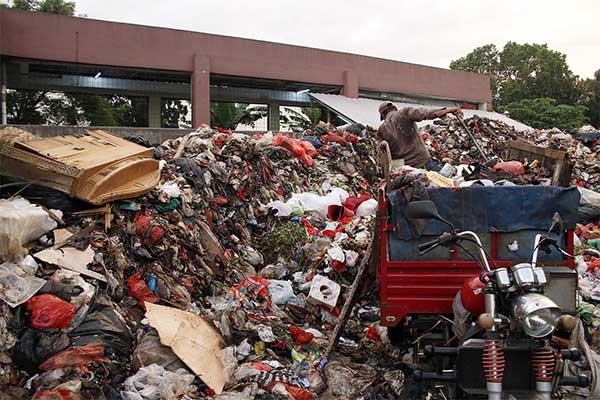 Petugas kebersihan membersihkan timbunan sampah di dalam Pasar Cisalak, Cimanggis, Depok, Jawa Barat, Rabu (6/2).