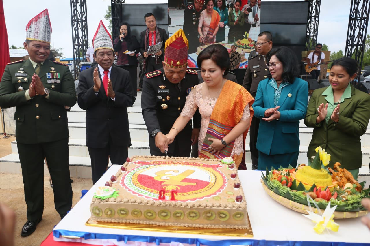Kapolres Tapanuli Utara AKB Horas Silaen didampingi istri memotong kue dalam rangka HUT ke 73 Bayangkara. 