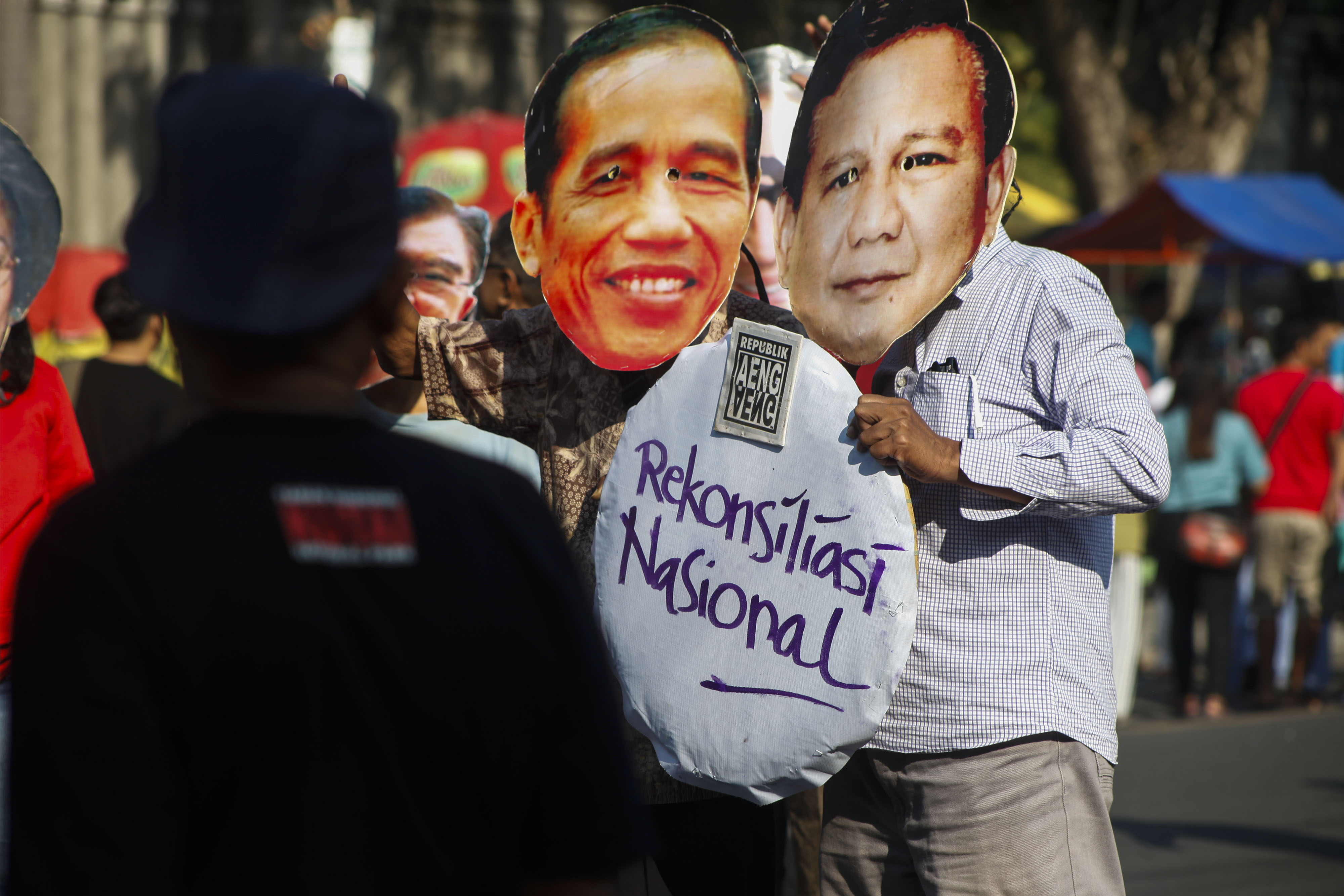 Warga memakai penutup wajah bergambar peserta Pilpres 2019, Joko Widodo (kiri) dan Prabowo Subianto (kanan) saat HBKB di Solo.