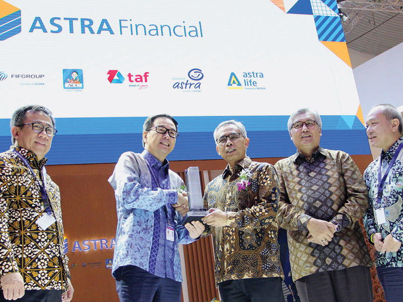 Presiden Direktur PT Astra International Tbk Prijono Sugiarto  memberikan cendera mata kepada Ketua Dewan Komisioner OJK Wimboh Santoso. 