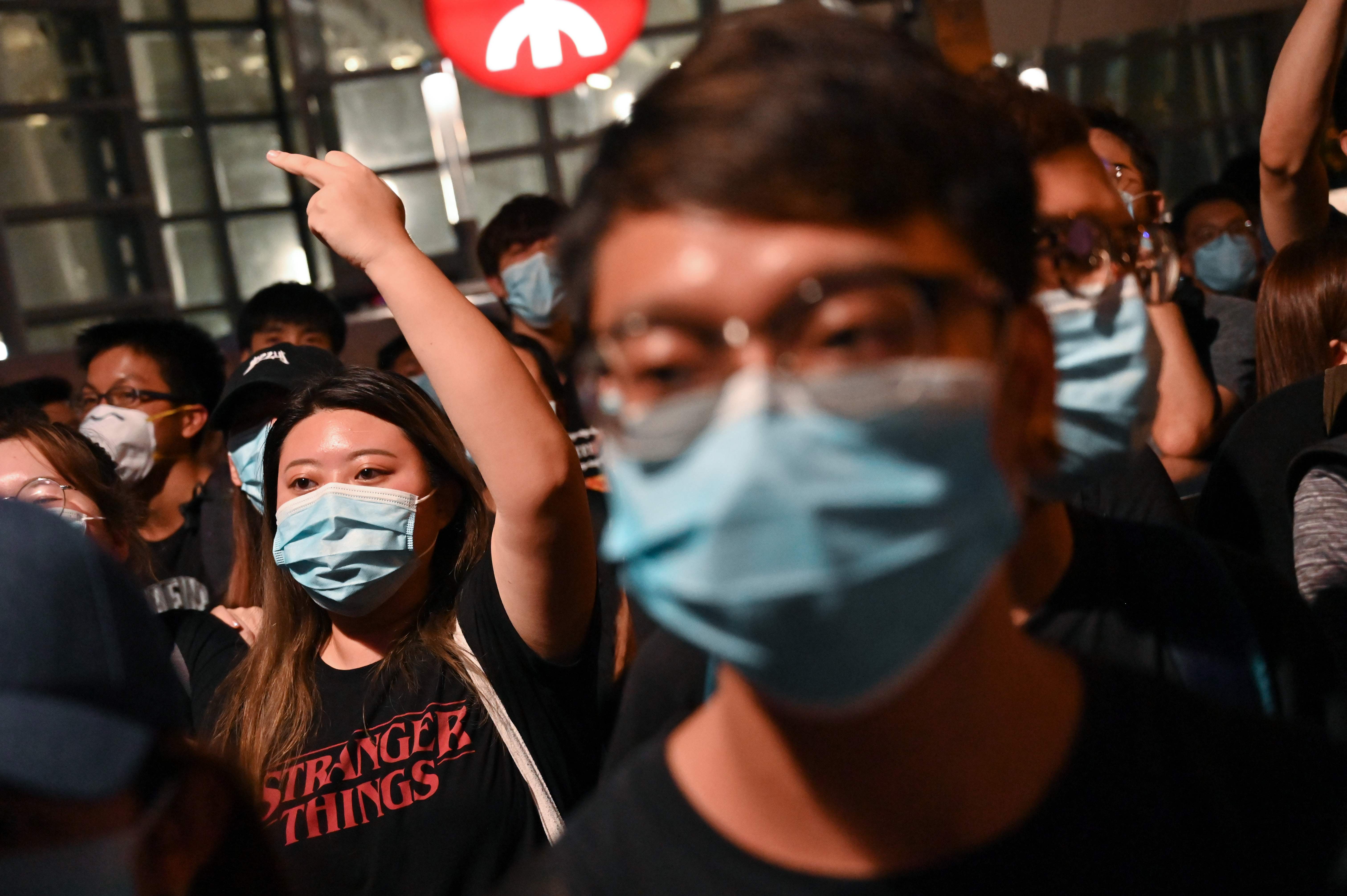 Para pengunjuk rasa meneriakkan slogan-slogan di luar stasiun kereta api Kowloon Barat selama demonstrasi menentang RUU ekstradisi  