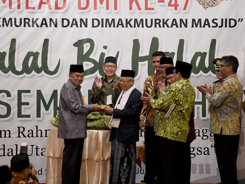 Wapres yang juga Ketua Umum Pimpinan Pusat DMI Jusuf Kalla (kiri) memberikan potongan nasi tumpeng pada Wapres terpilih KH Ma