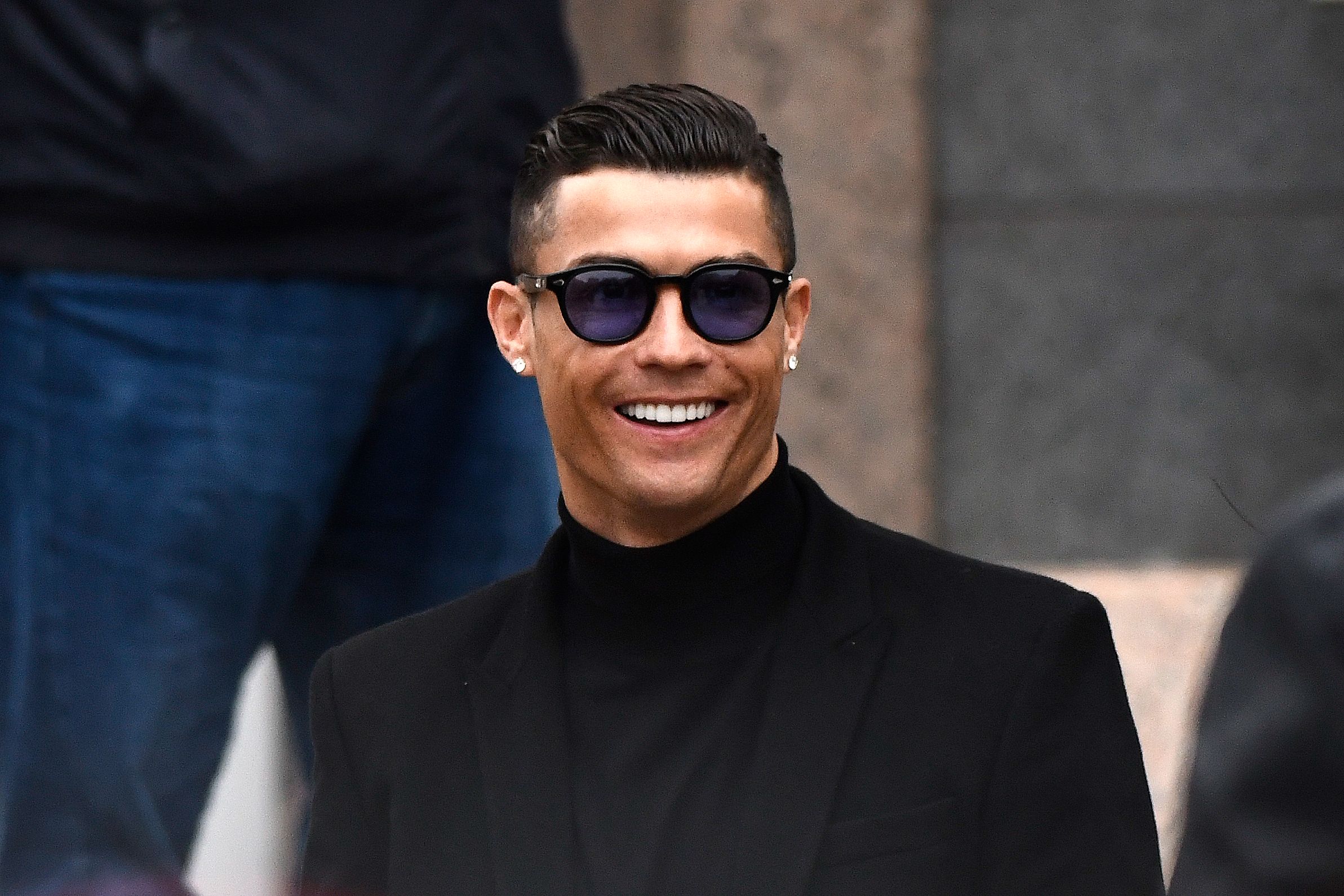 mantan pemain Real Madrid Cristiano Ronaldo tersenyum ketika ia pergi setelah menghadiri sidang pengadilan untuk menghindari pajak di Madrid